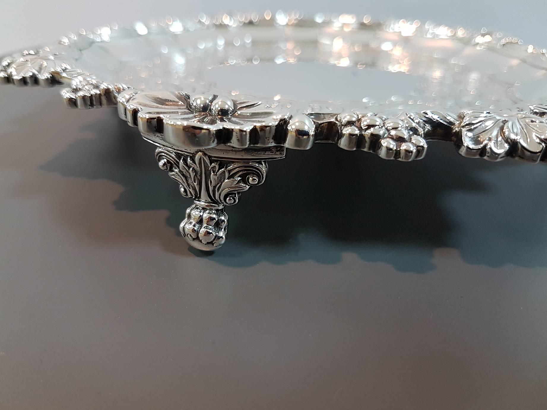 These antique George IV sterling silver salvers have a circular shaped form.
The raised borders are encircled with chased fruiting vine ornamentation accented with alternating leaf designs.
In the middle of the salvers there were a motto with a