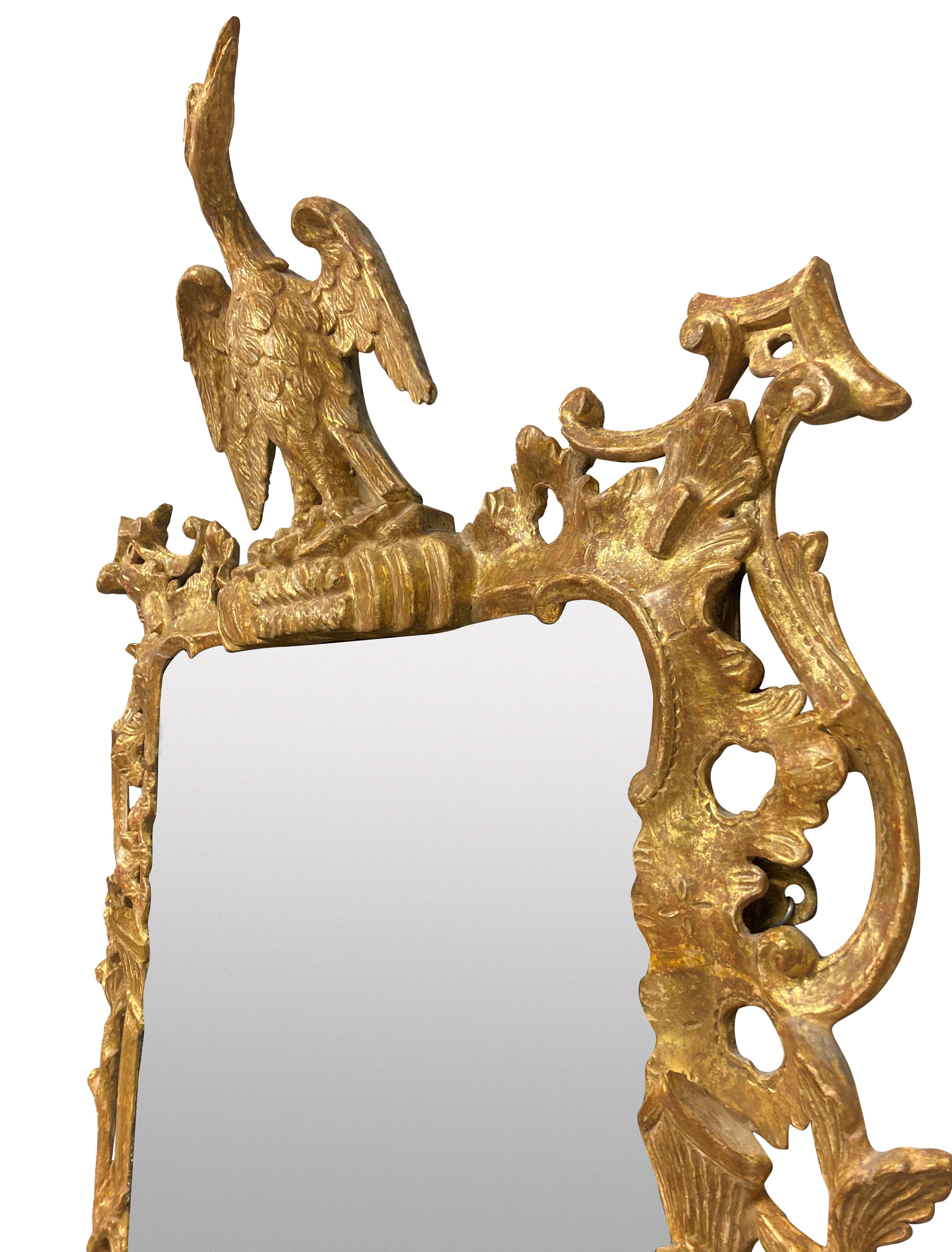 A fine English George III carved and water gilded Chippendale period mirror. The gilding is dry scraped, with foliage, pagodas and surmounted by a hoho bird. The mercury mirror plate is the original, with some foxing but in overall good condition.