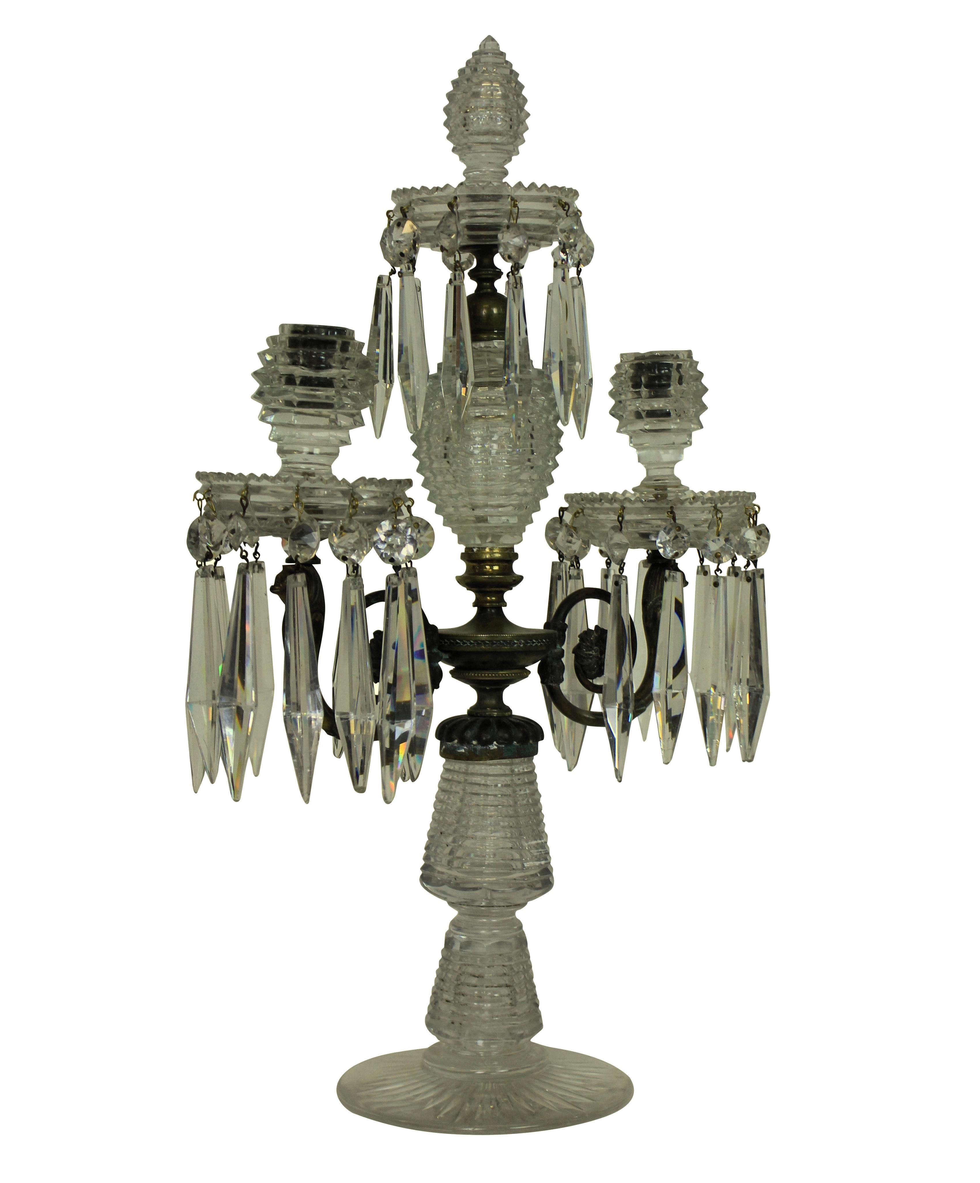 An English George III cut-glass and gilt bronze candelabrum. Handcut in a 'bee hive' design, with twin branches and a central spike.
     