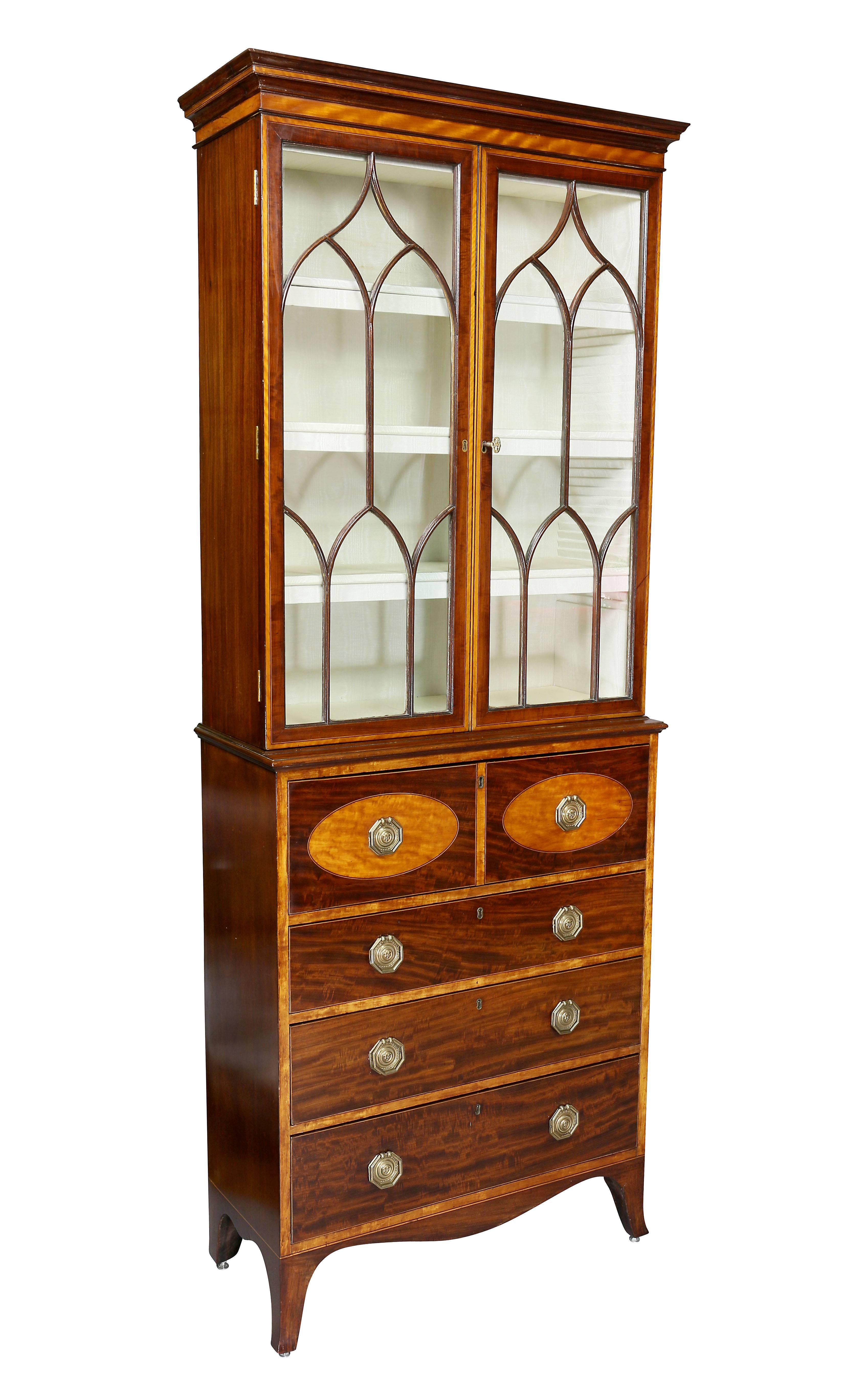 With rectangular cornice over a pair of gothic mullioned doors enclosing a fitted interior, the base with drawer enclosing a fitted desk interior all over three drawers ending on splayed legs.
 