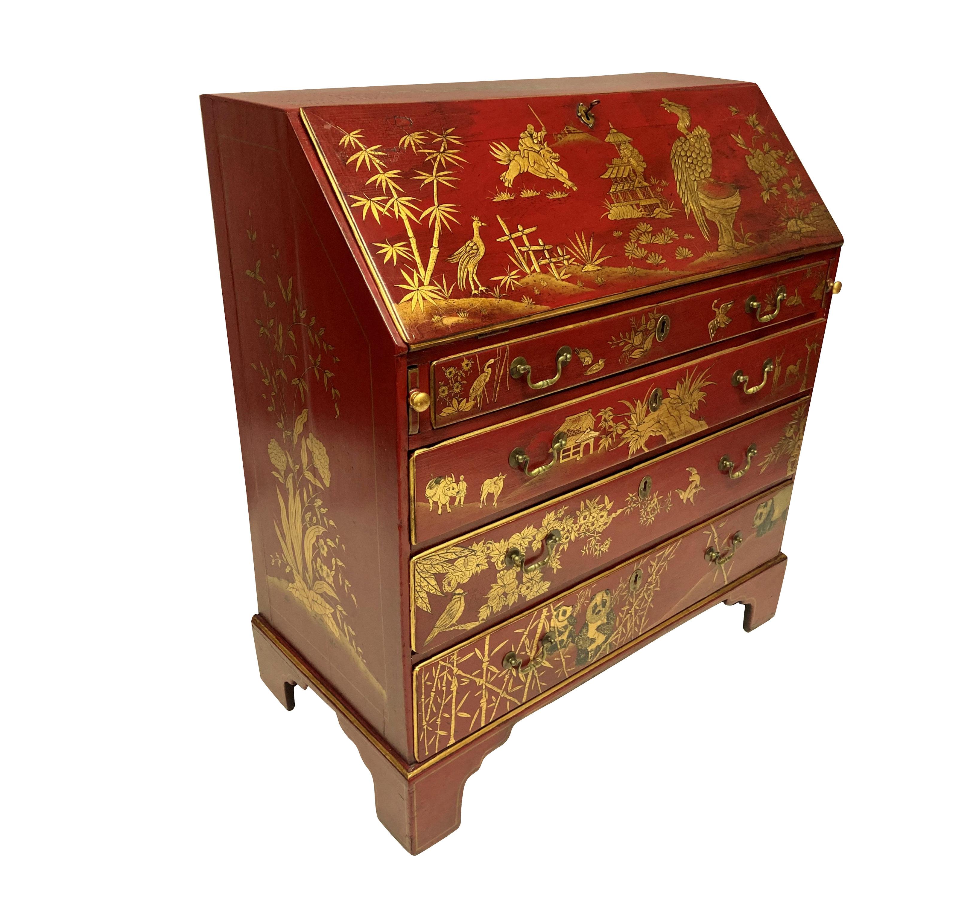 A fine English George III scarlet gilt-japanned secretaire; all the surfaces superbly decorated with rich gilt chinoiserie on a scarlet red background, the fall-front opening to reveal a similarly decorated writing slide and various pigeon-holes and