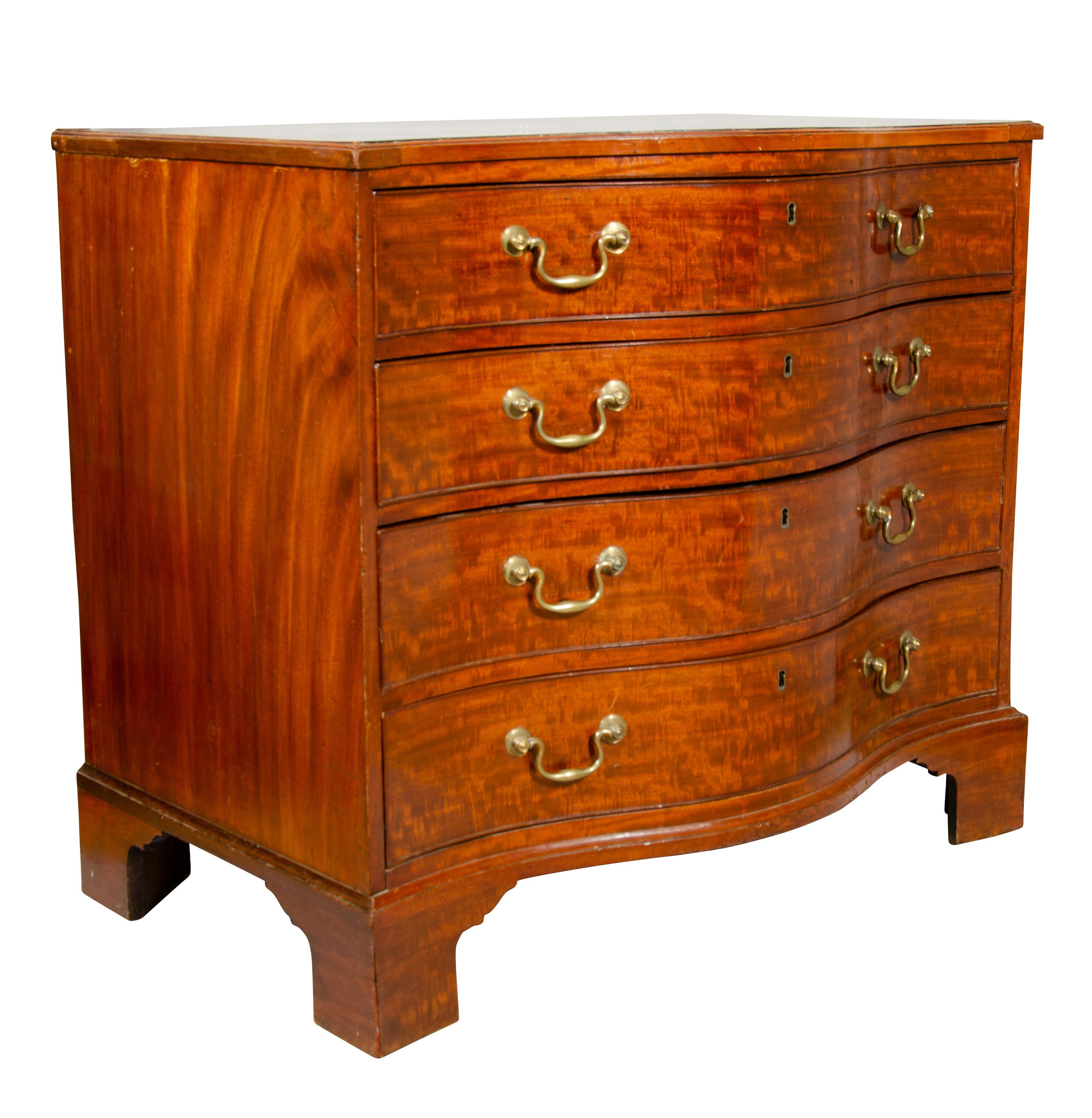 Constructed of the finest mahogany, serpentine top over a conforming case containing a brushing slide and four drawers. The top with fitted compartments. Original bail handles, bracket feet.