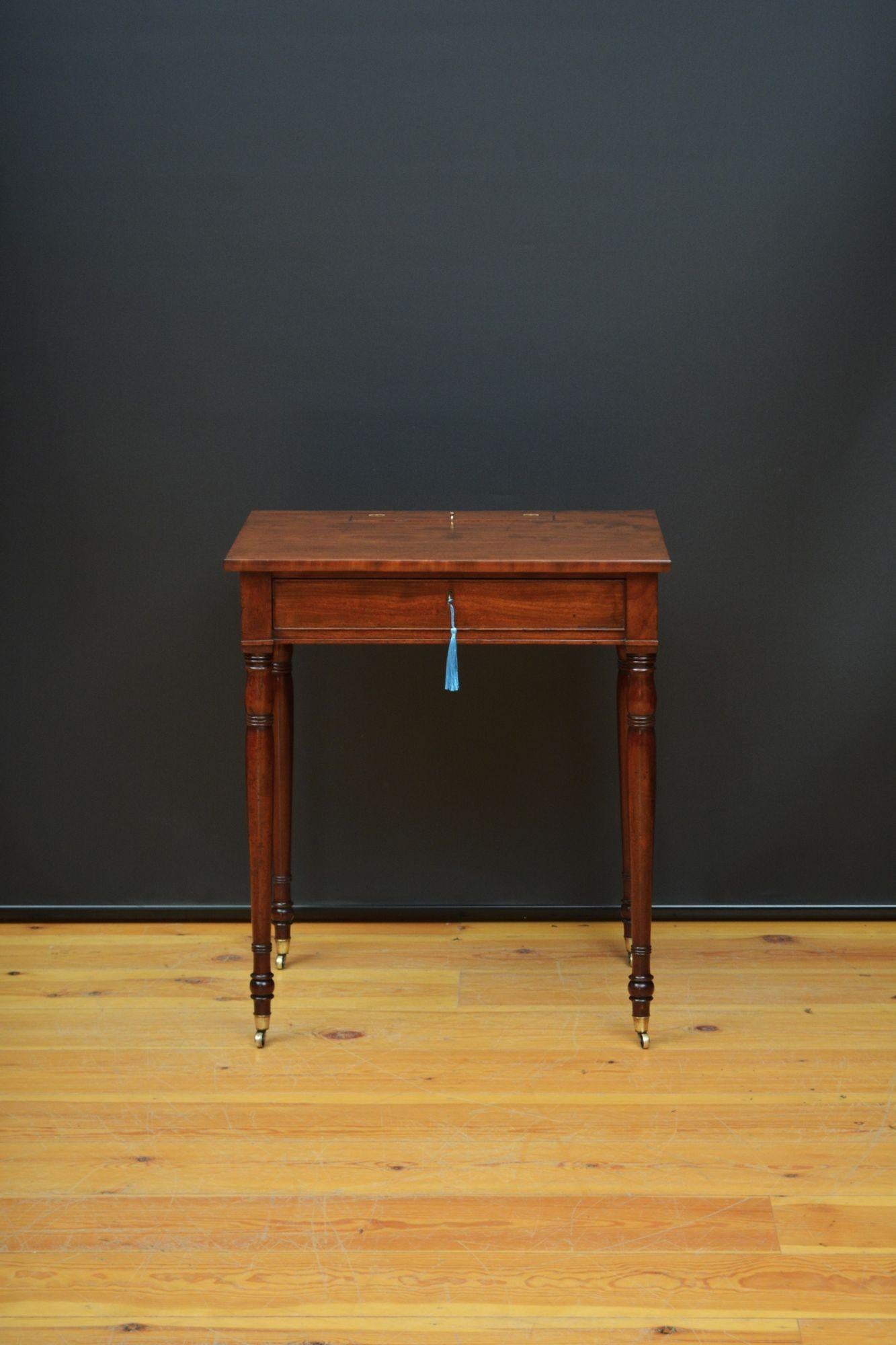 Sn5653 Tavolino in mogano georgiano inglese, con piano in mogano figurato con apertura a ribalta che racchiude un vassoio per le penne e due calamai sopra un cassetto con fregio a gallo dotato di serratura funzionante e chiave. Il tutto poggia su