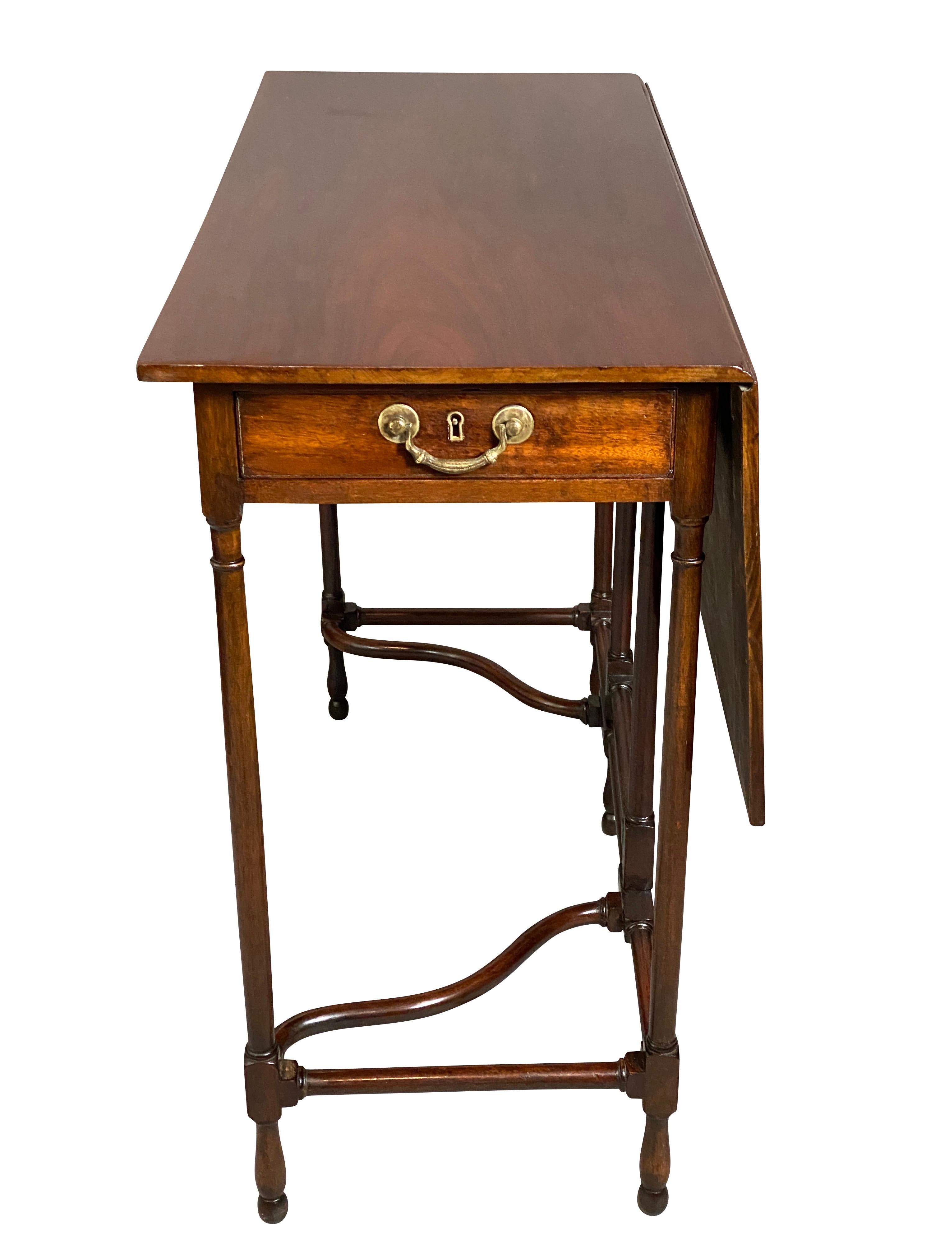 With a rectangular top and hinged drop-leaf, contains a frieze drawer, turned circular legs and wonderfully turned and shaped stretchers. Turned feet.
The stretcher configuration allowed the user to place their feet under the table to use as a