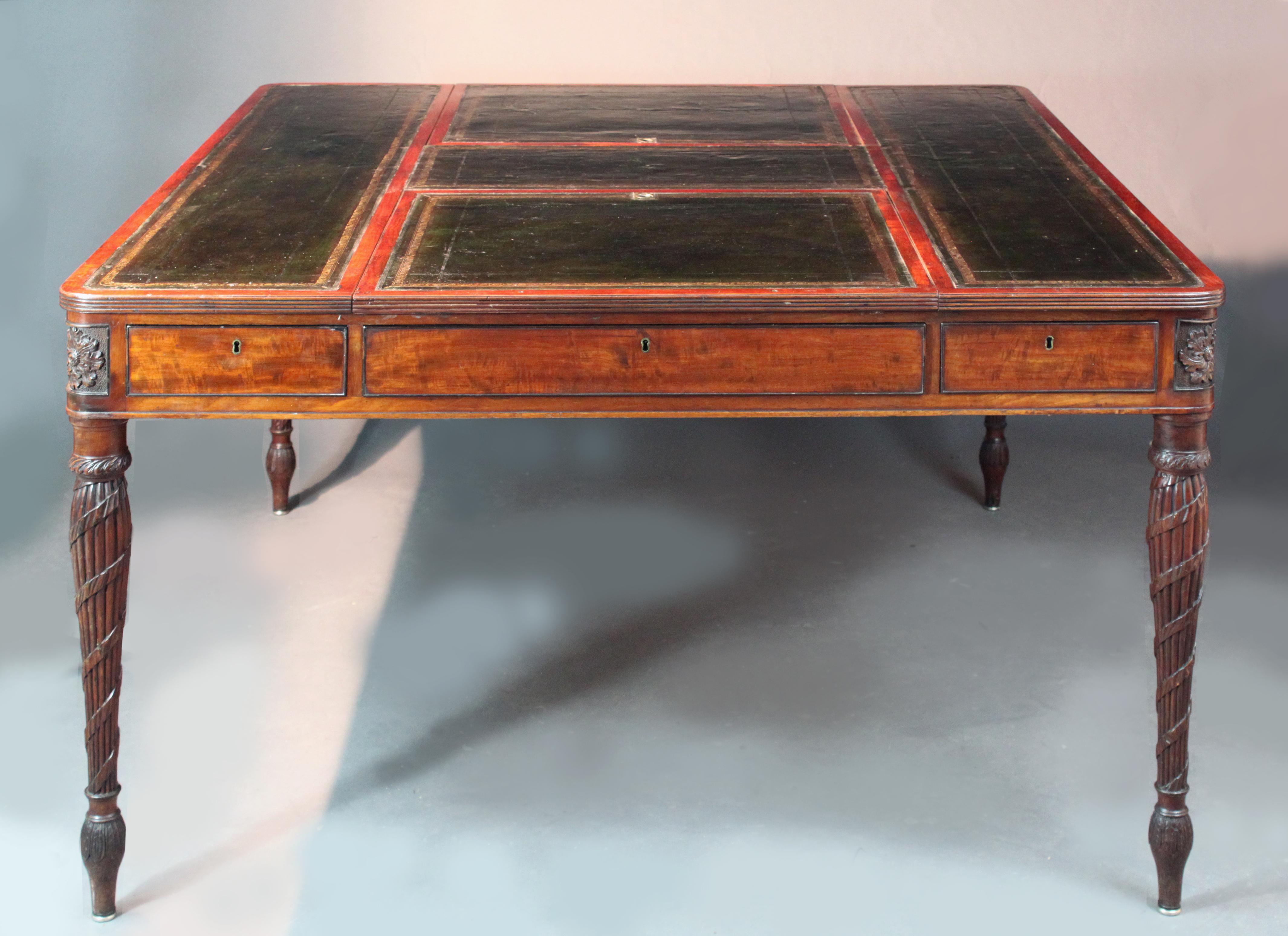 An exceptional George III partners writing table in fiddle grain mahogany with ebony cock beading, 2 adjustable slopes, original dark green leather top and finely carved legs and patera; good original colour.