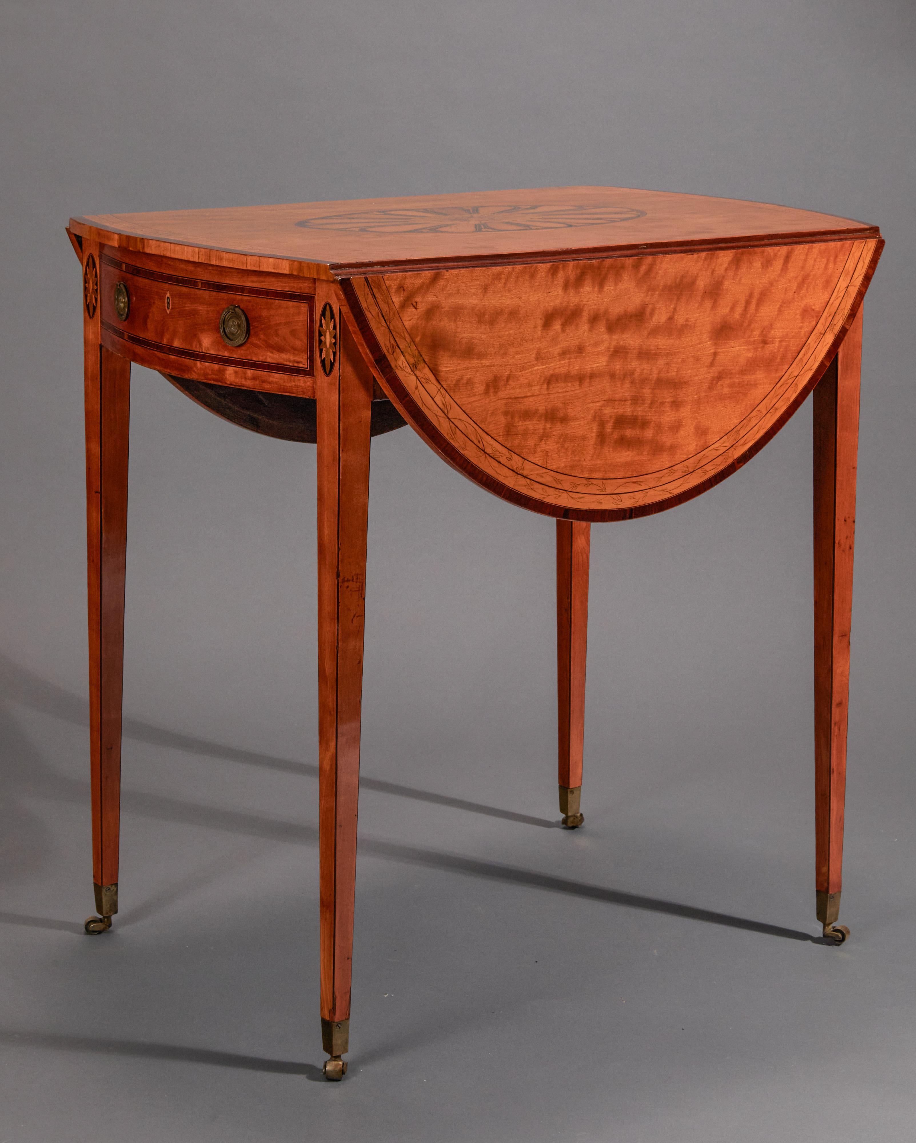 The satinwood top with two drop leaves, the edges vaneered in mahogany edging with line and leaf inlay. The central part of the top inlaid with medallion and conch shell. The whole raised on square tapering legs with original brass box casters.