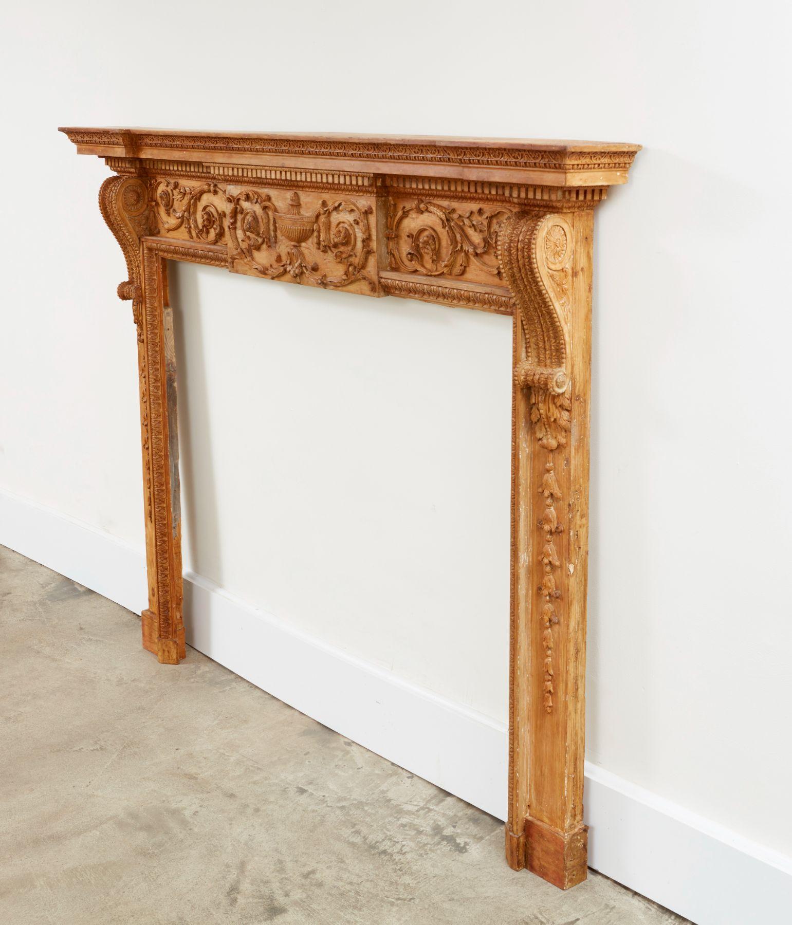Very fine George III period carved pine mantel, the pediment with stepped ends having band of ringed rosettes over dentil molded frieze over two scrolls with acanthus and water leaf carving, the central tablet with urn and trailing honeysuckle