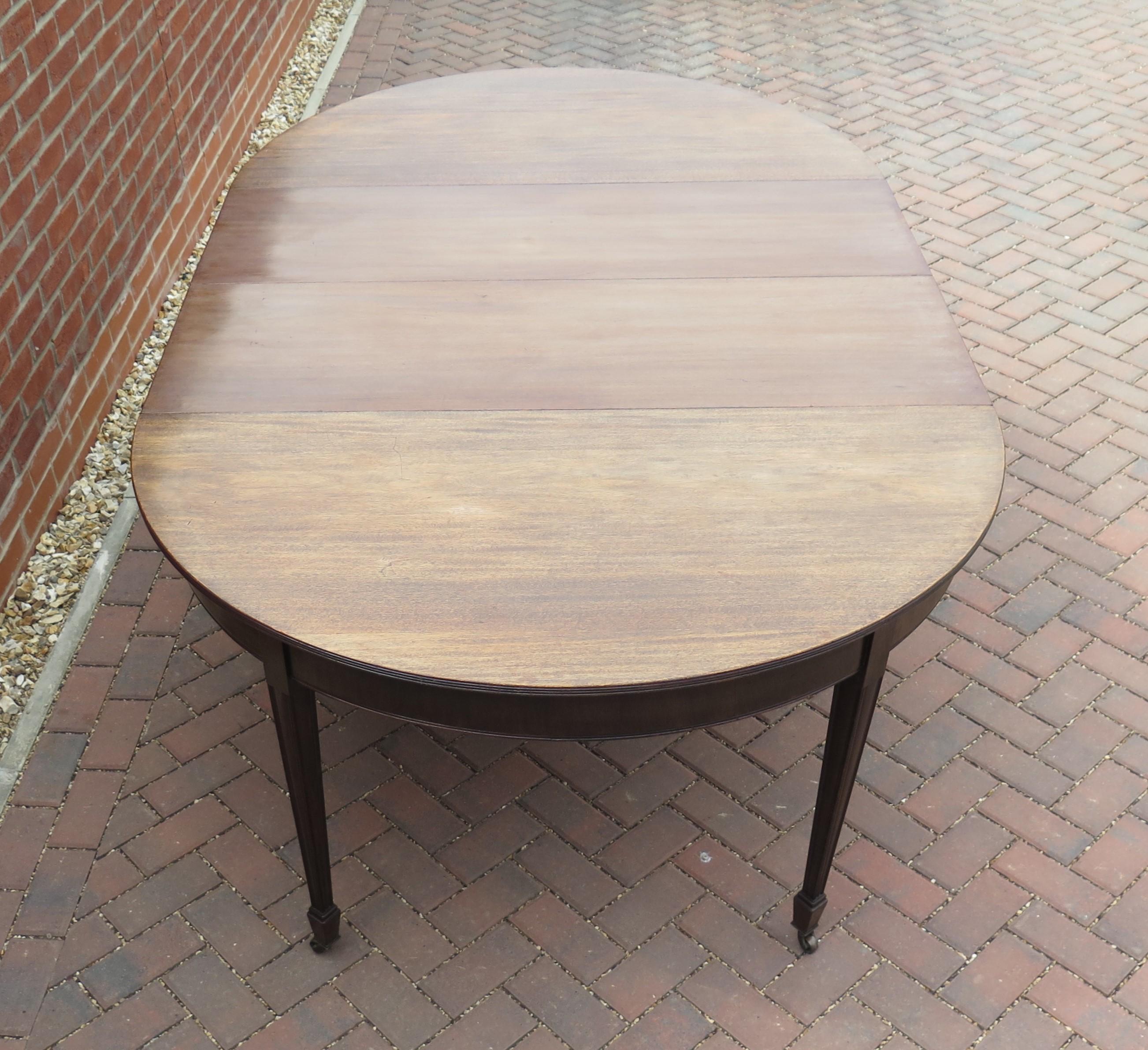 This is a high quality English extending dining table made from hardwood, in the period of George III, during the late 18th century, circa 1785.

This table will seat 10 people on account of its large width of over 54 inches plus the semi circular