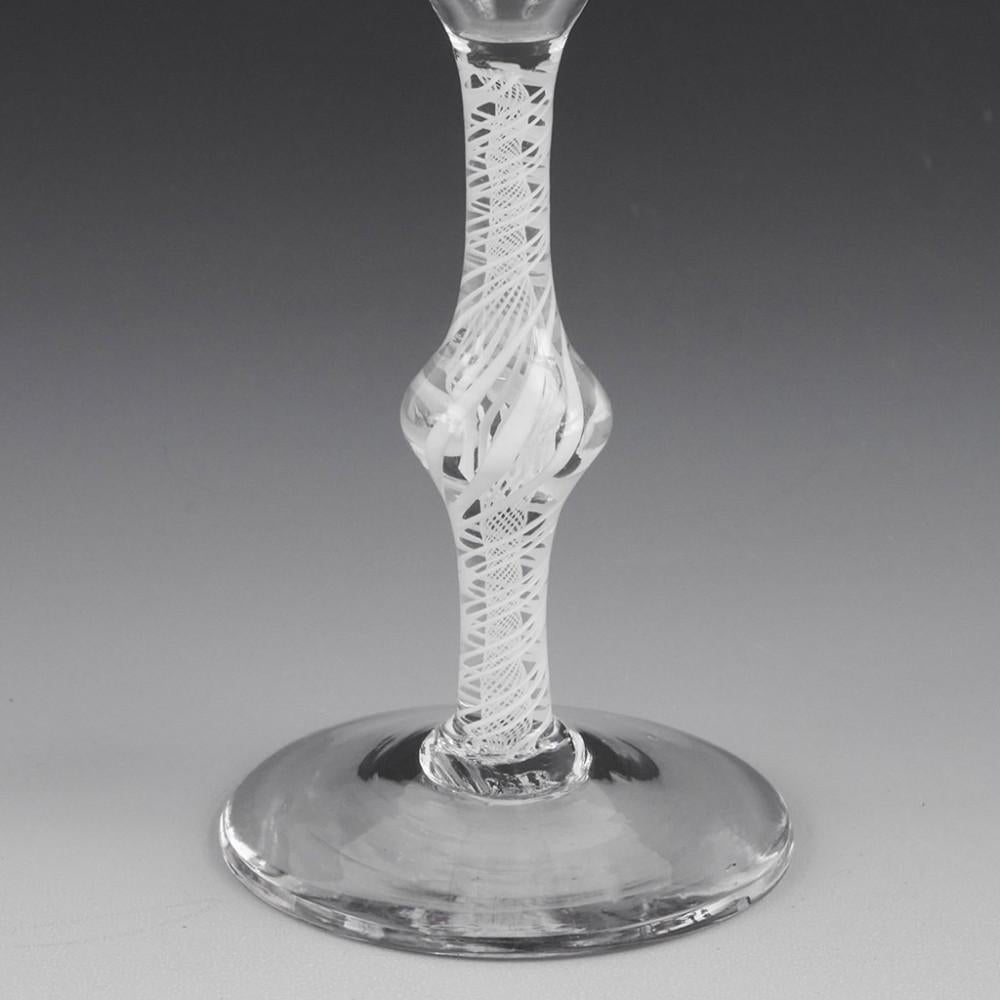 Heading : Georgian Knopped Opaque Twist Wine Glass c1765
Period : George III
Origin : England
Colour : Clear.
Bowl : Ogee
Stem : A pair of three ply spirals outside a vertical gauze. Central swelling knop
Foot : Conical
Pontil : Snapped
Glass Type :