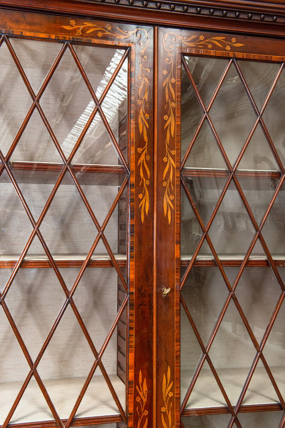 Maravillosa e impresionante librería de caoba georgiana de principios del siglo XIX, de gran calidad y con frentes quebrados, con cornisa moldurada y decoración de botones tallados, sobre cinco puertas acristaladas en forma de rombo, cada una de