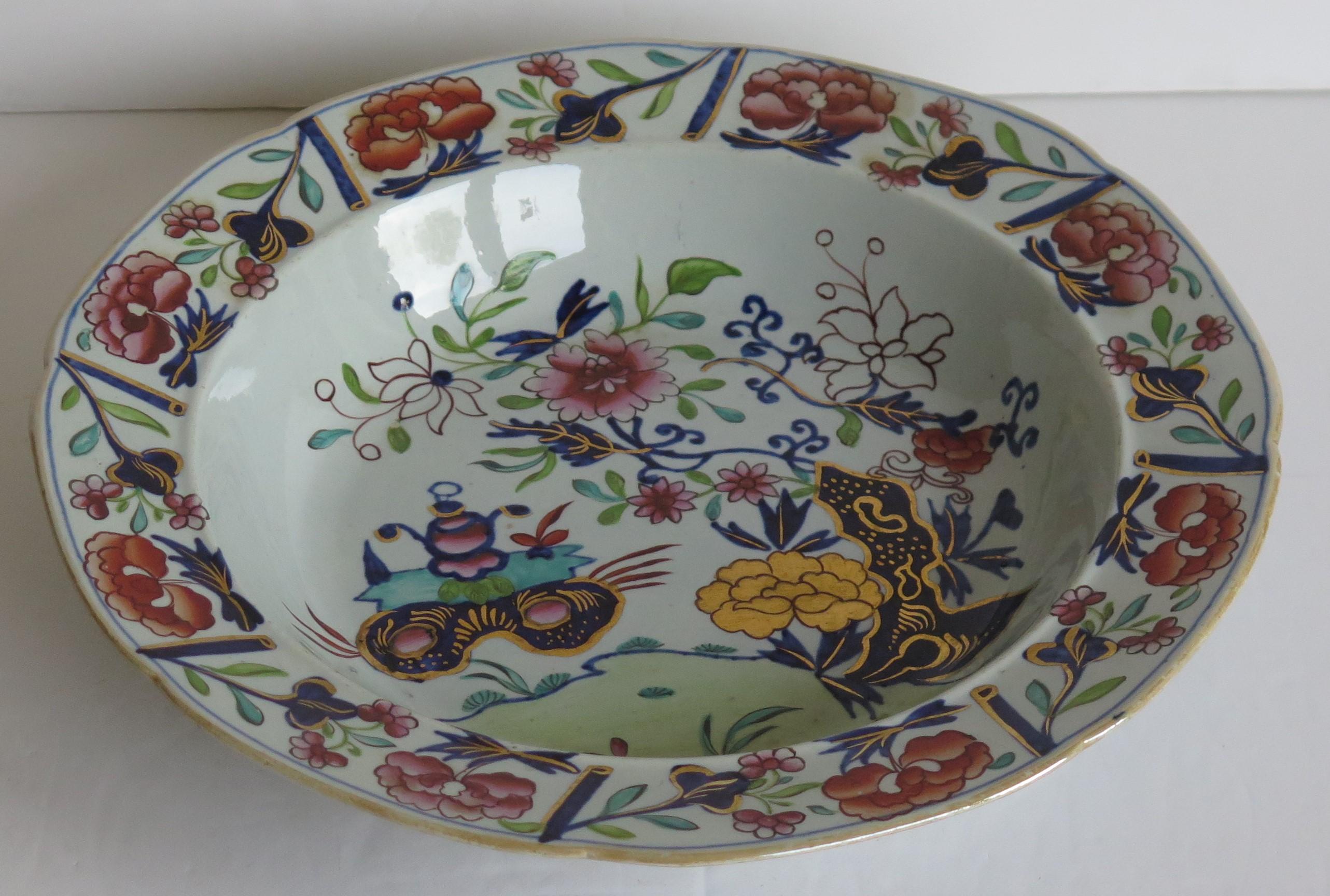 This is a fine Ironstone pottery soup bowl or deep plate made by the Mason's factory at Lane Delph, Staffordshire, England and beautifully decorated in the Small Vase, flower & Rock Pattern, fully stamped and dating to the earliest period of Mason's