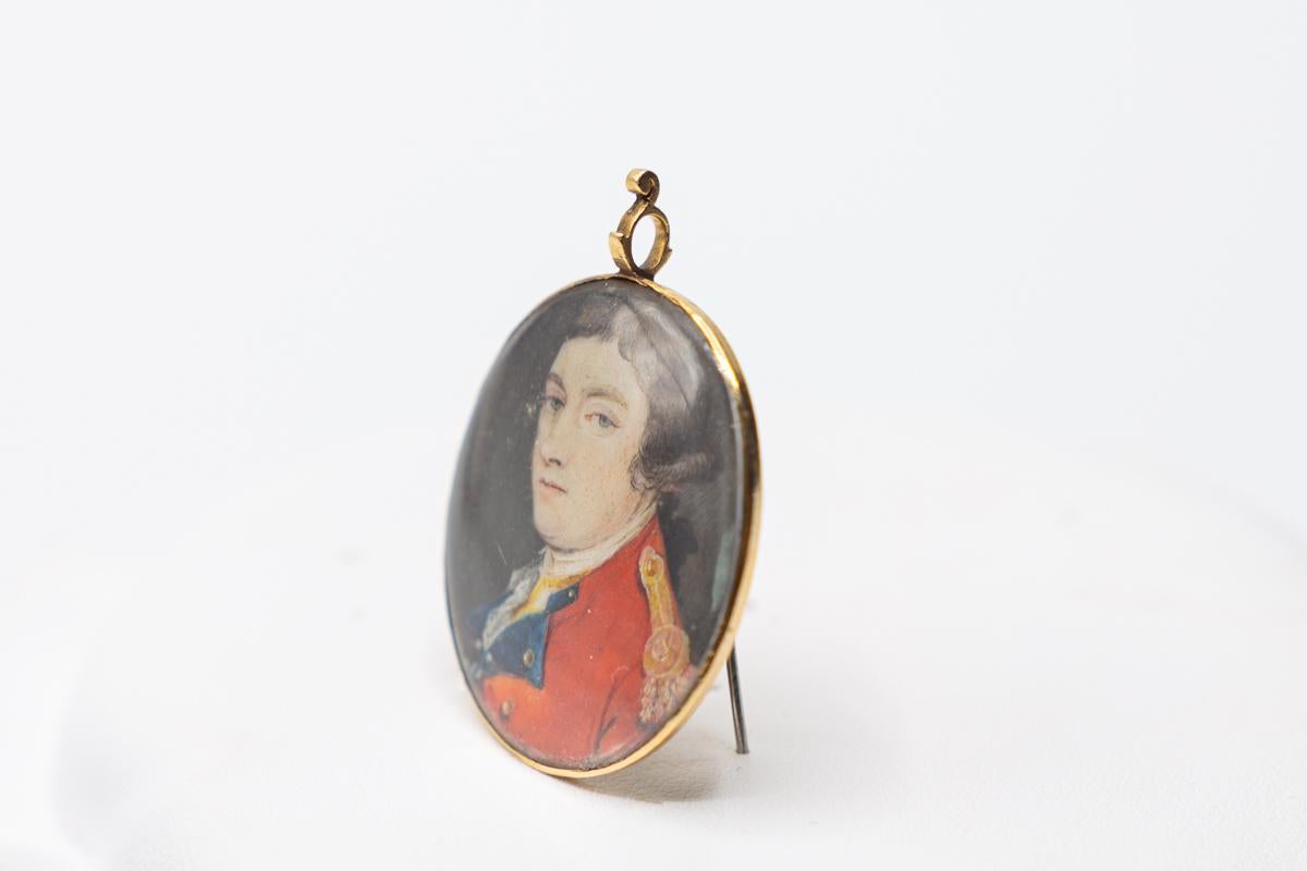a most attractive and well executed Georgian portrait  miniature of a young army officer Painted in high English dating from c 1790.

The portrait is watercolor on an oval water housed in a gold frame with suspension loop.

Probably originally worn