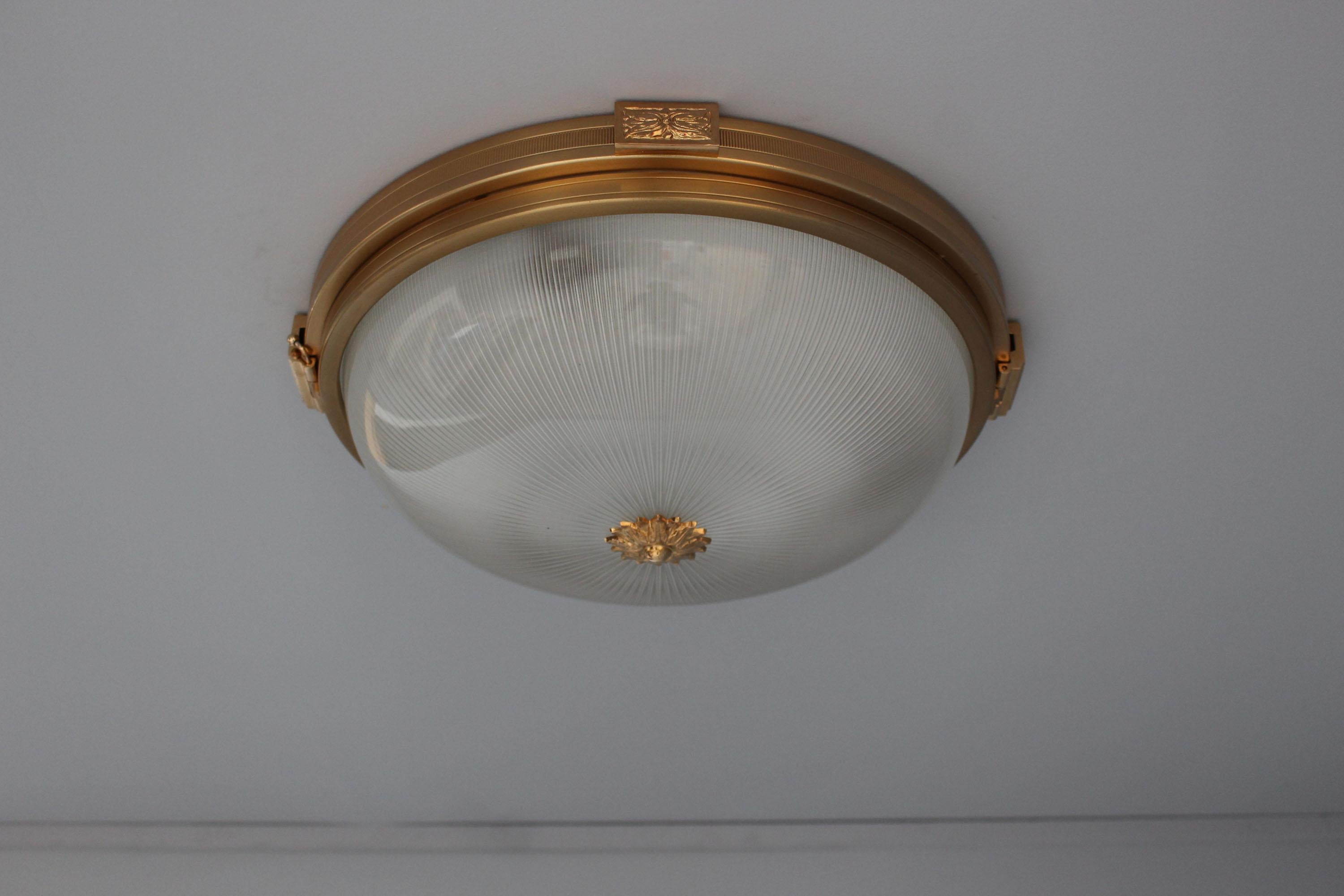 A French 1940s Neoclassical gilded brass flush mounts with a fluted glass diffuser.
US rewired with 3 high heat porcelain Edison sockets and UL listed.
 