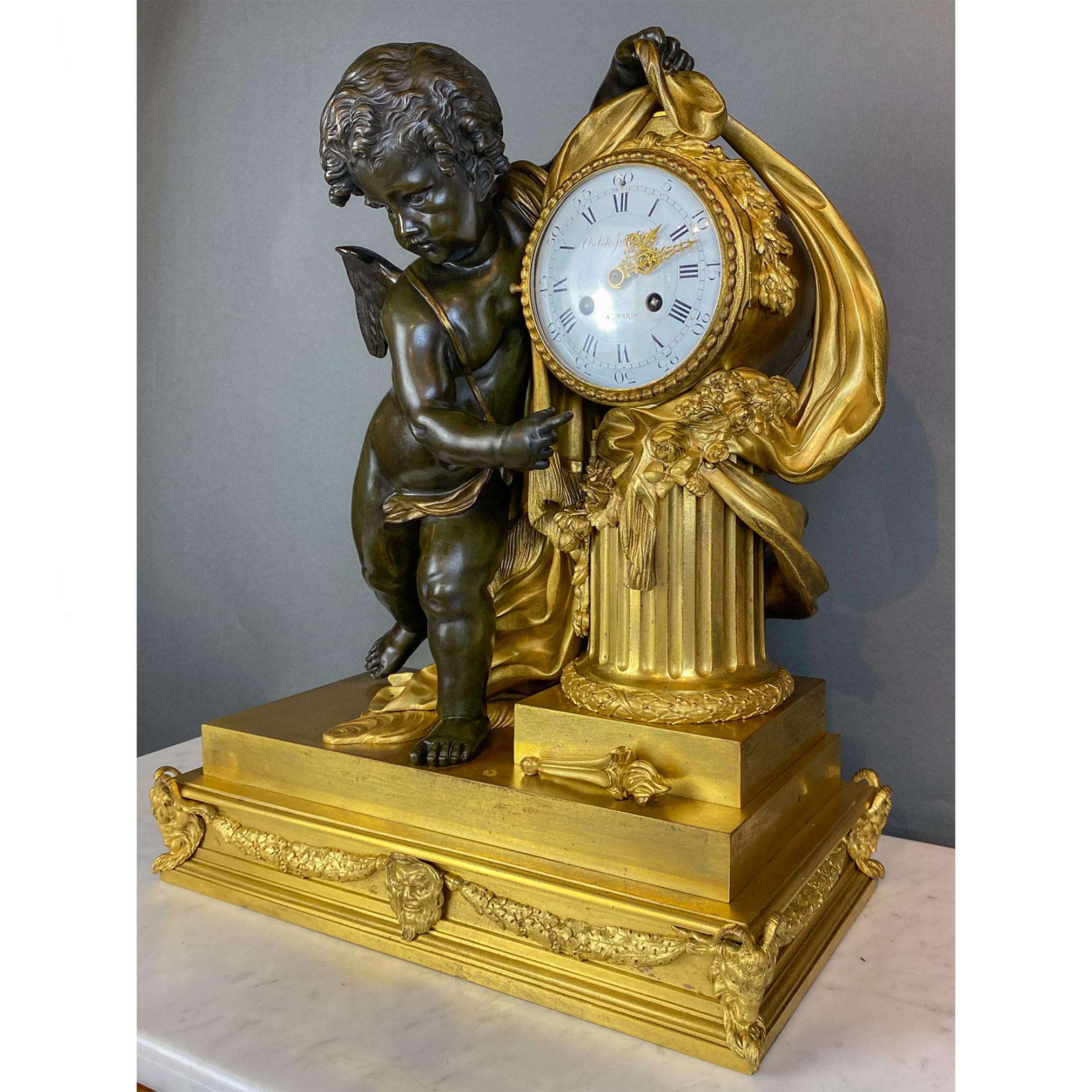 An exquisite figural bronze mantel clock with Putti leaning on clock face which sits on a fluted column draped in garlands and fabrics. Sitting on a rectangular base ornamented with garlands and goat heads. 

Clock Maker: Antide Janvier

Origin:
