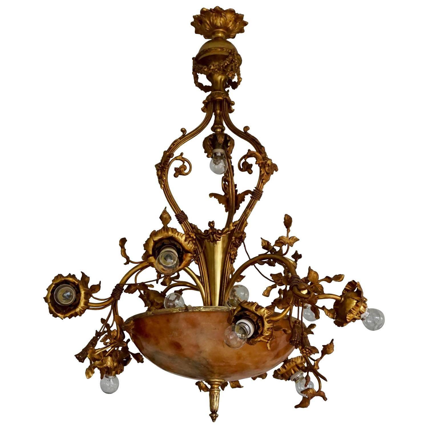 Lustre Belle Époque en bronze et albâtre, en forme de branches de roses tourbillonnantes et fleuries, début du XXe siècle. 
Dimensions : Diamètre 75 cm, hauteur 100 cm.