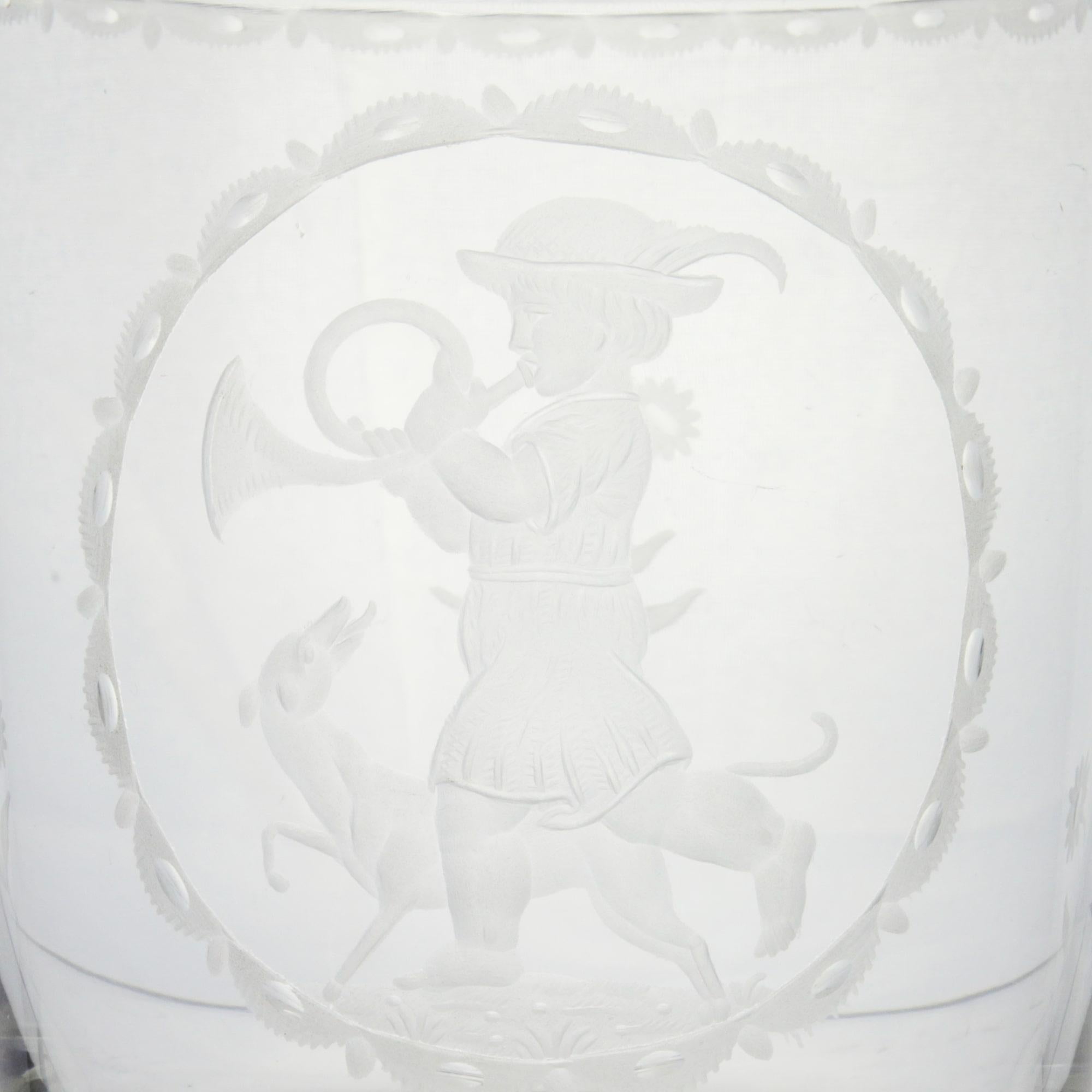 Un très beau gobelet en verre gravé conçu par Michael Powolny (1871-1954) pour Lobmeyr de Vienne. La pièce représente un garçon avec une corne et un chien à l'intérieur d'un médaillon gravé, représentant le mois de novembre. Le modèle date d'environ