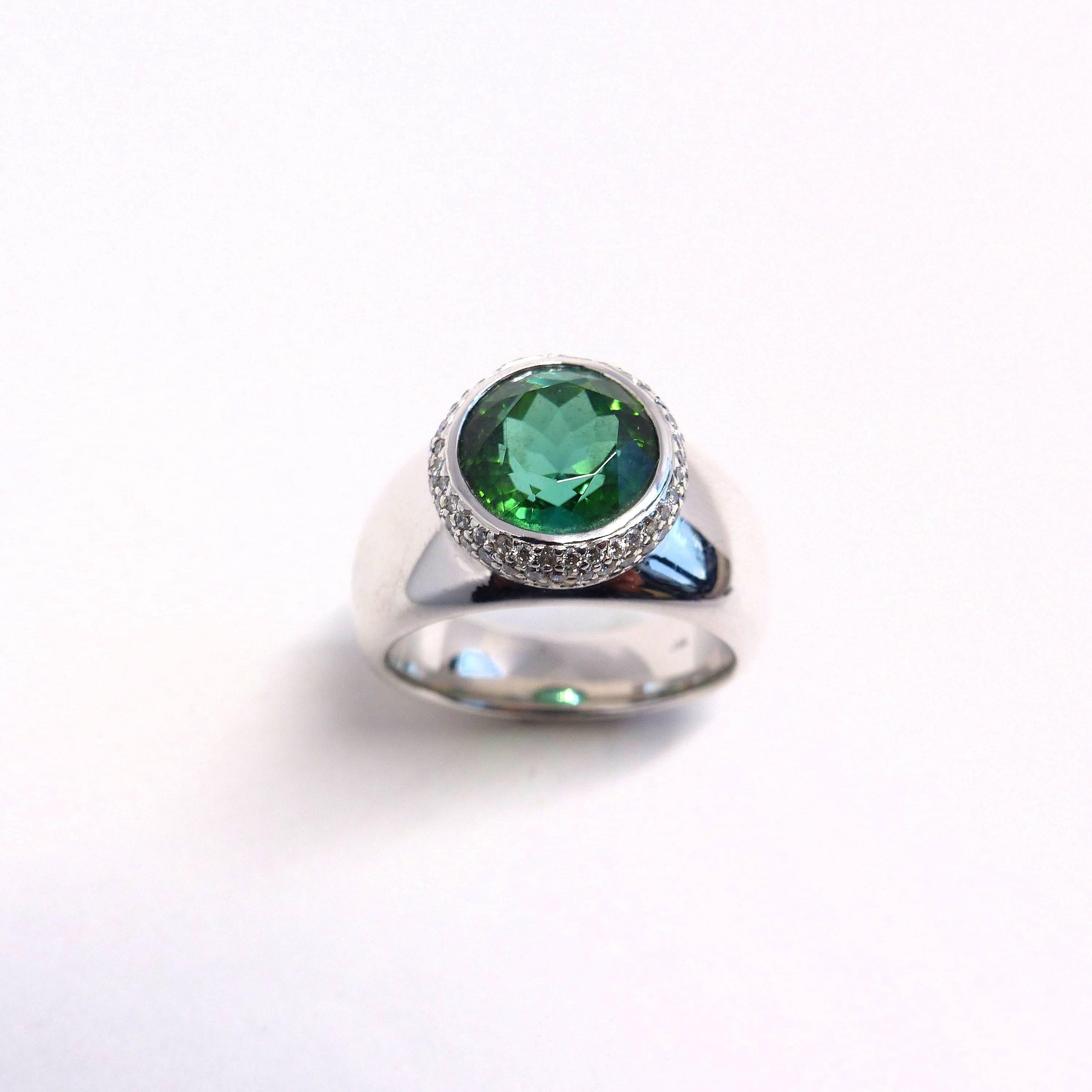 Thomas Leyser is renowned for his contemporary jewellery designs utilizing fine gemstones. 

This 18k white gold (18.75g) ring is set with 1x fine green Tourmaline (facetted, round, 10mm, 4.11ct) + 99x Diamonds (brillant-cut, 1mm, G/VS, 0.54ct).