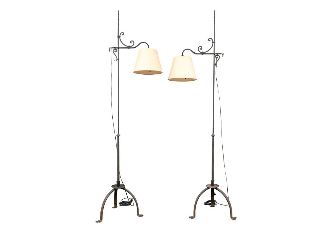 Une paire particulièrement remarquable de lampadaires en fer de forme traditionnelle délicate reposant sur des bases tripodes avec un pied primitif à trois orteils. Les parties supérieures sont ornées d'éléments en fer à volutes et d'un épi de
