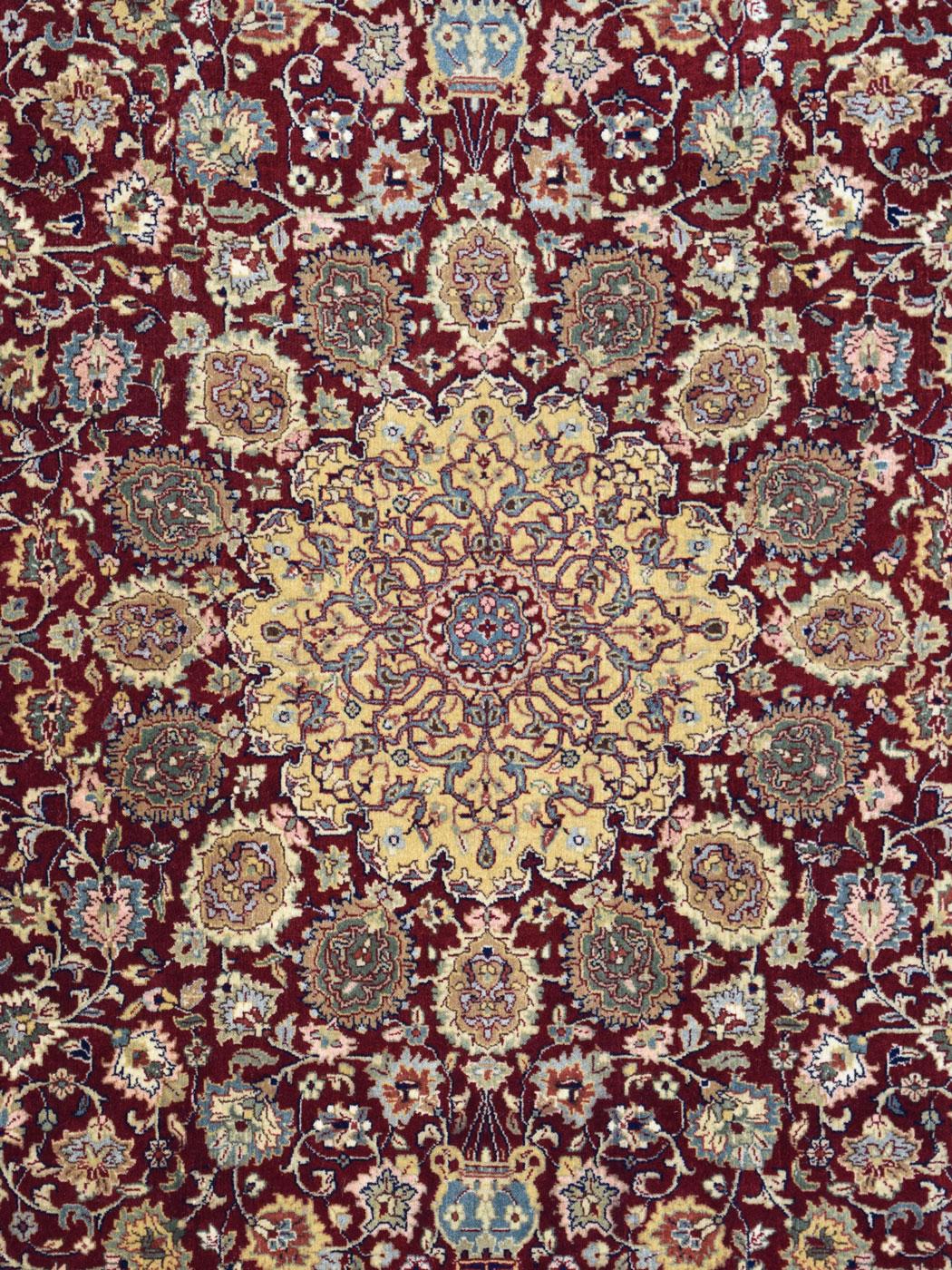 Inspired by classic and antique Persian Tabriz carpets, this maroon and gold Tabriz carpet measures 4’7” x 6’9” and is in brand-new condition. Entirely hand-knotted, this carpet features a stunning 16-pointed medallion and has a formal butterfly and