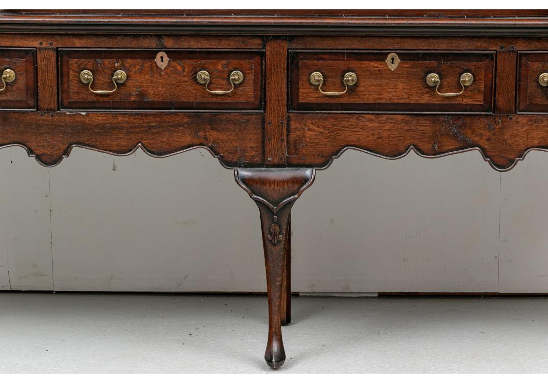 With label- Henry Venables, Stafford England. In a dark stain beautifully constructed in two sections. The top with carved cornice over three center shelves with slots for plates, flanked by sides with doors inlaid with stars and small frieze