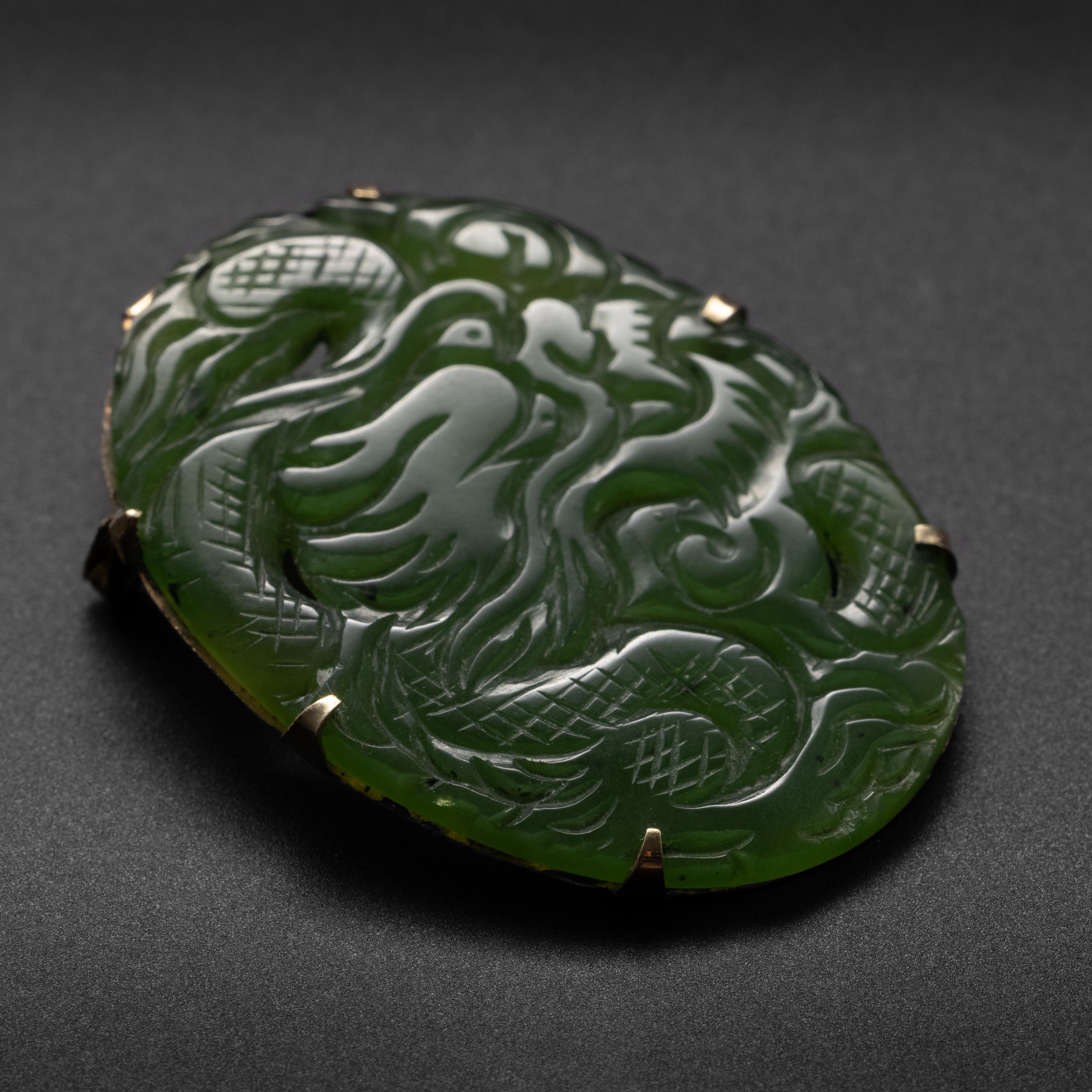 Uncommonly translucent nephrite jade with exceptionally fine coloring has been skilfully carved into the form of an expressive dragon contained within an oval form.

The 40.56mm x 29.72mm x 2.82mm nephrite is so translucent you can see your finger