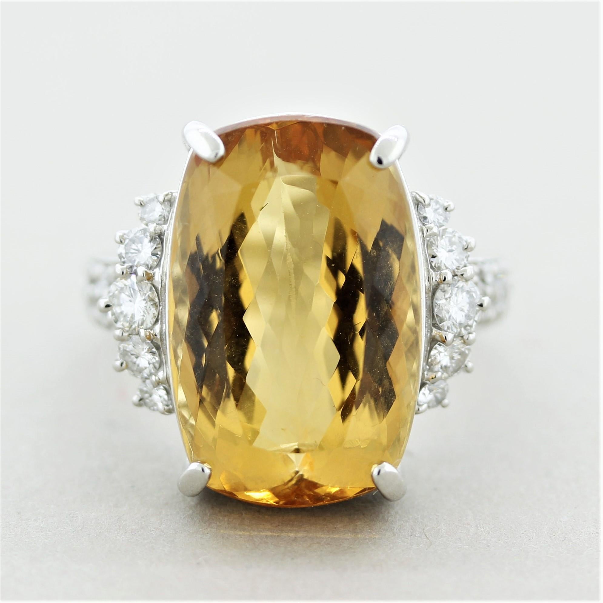 A special ring featuring a large, beautiful, and rare gemstone. It is an imperial topaz weighing a substantial 21.65 carats. It has the ideal yellow-orange gold color that is highly desirable with no eye-visible inclusions allowing the stones