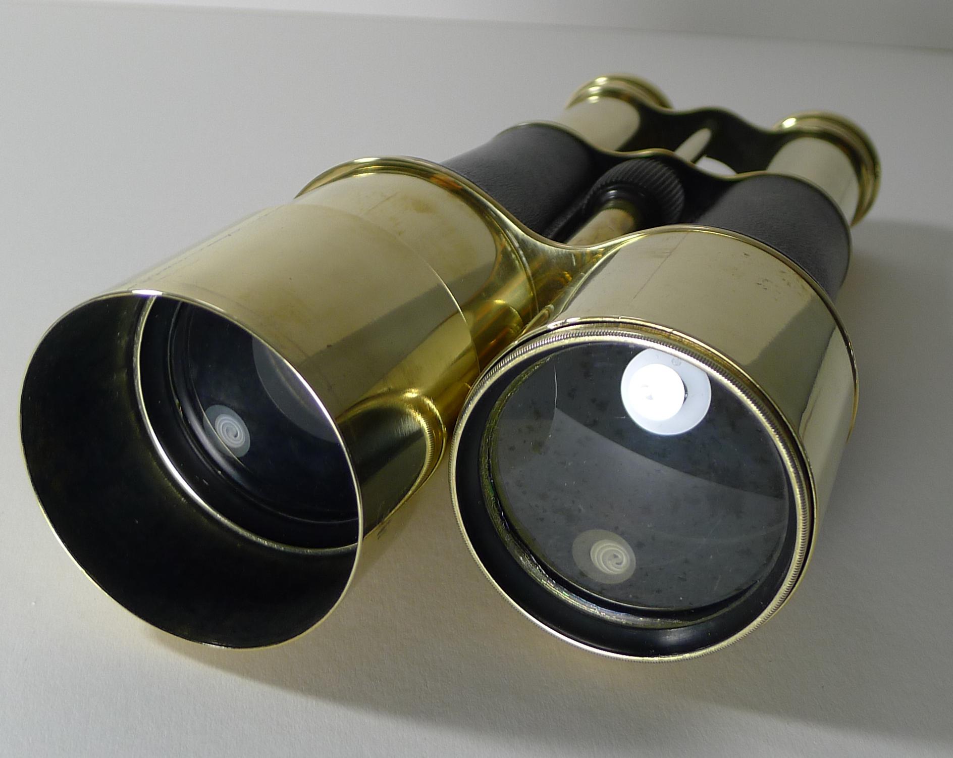 A really unusual and impressive pair of World War 1 pair of British issued military binoculars meticulously professionally cleaned and polished, restoring them to their former glory; the barrels wrapped in leather.

The bridge is stamped with the