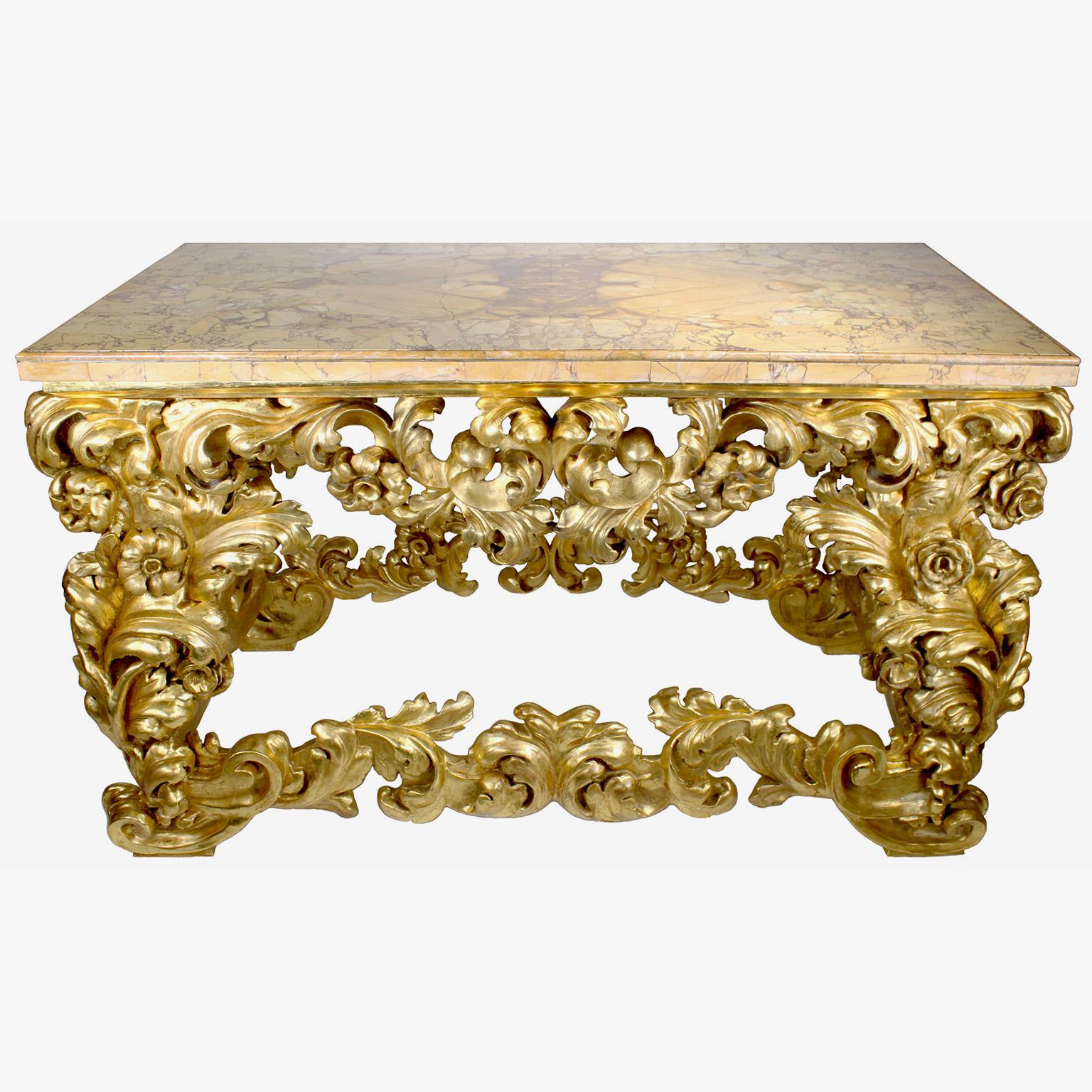 A large and very fine Italian 19th century Florentine Baroque style giltwood carved wall console table with marble top. The ornately carved rectangular shaped scrolled body frame in a leaf and floral design with scrolling foliate and acanthus,