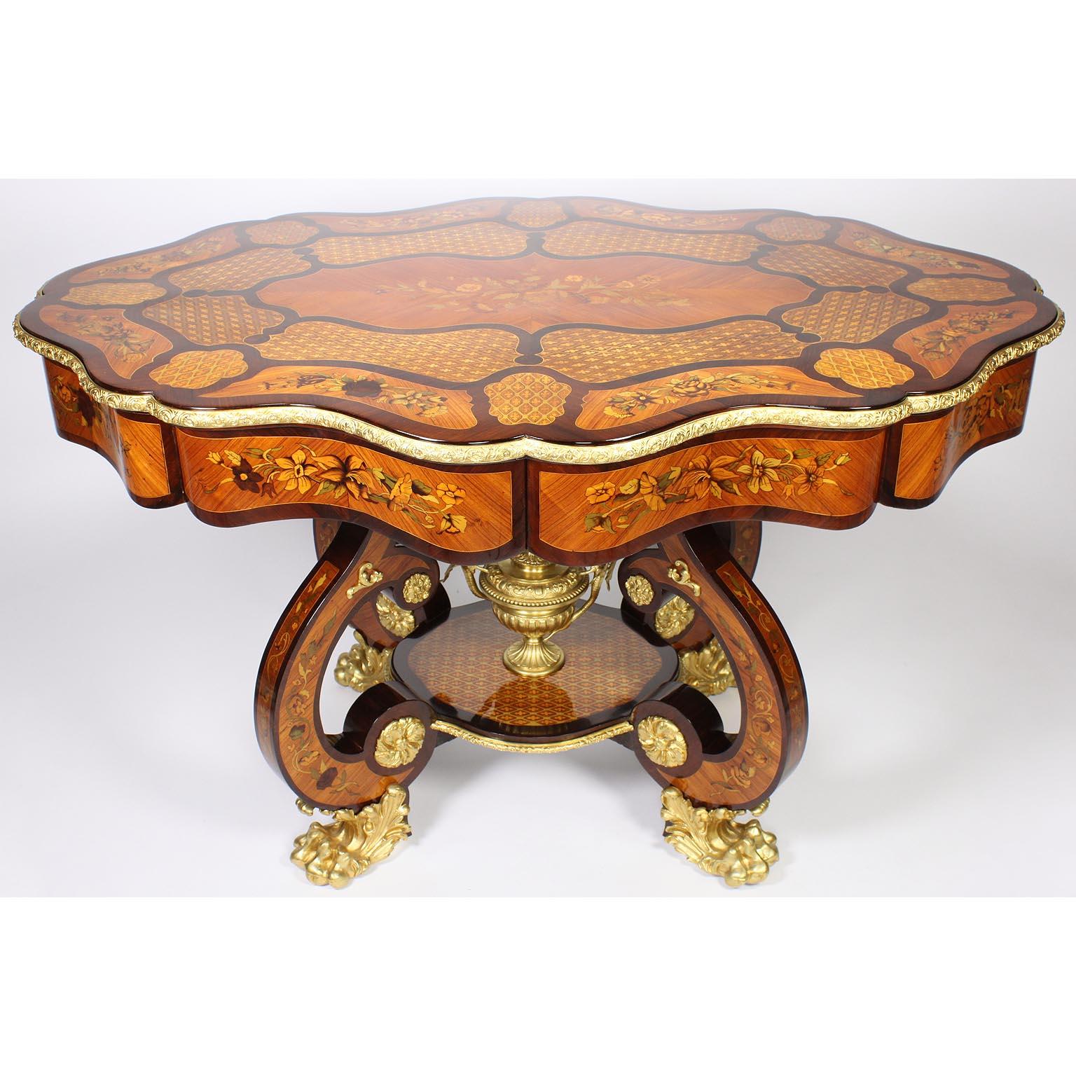 A fine Italian 19th century mahogany, satinwood and tulipwood floral marquetry and gilt-bronze mounted center table or writing desk. The serpentine inlaid shaped top centered with a marquetry floral arrangement medallion, surrounded by sections of