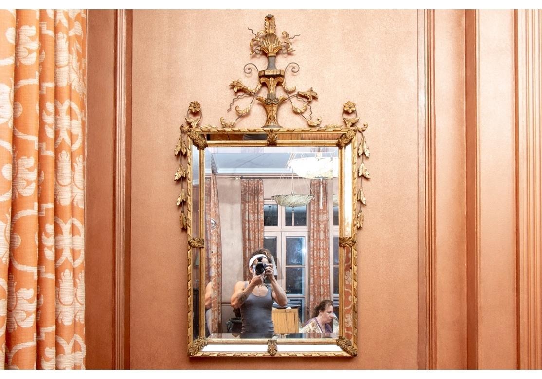 Fabriqué en Italie, un miroir mural sectionné, peint et doré, élégant et complexe. Un beau miroir biseauté de style Adam avec un entourage de miroir segmenté. Avec un cimier classique de style Adam avec une feuille d'acanthe et une palmette au