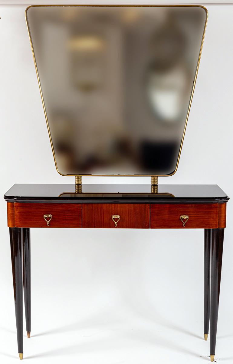 Console italienne de style déco avec miroir en laiton modifié en forme de bouclier.  La console ou le meuble-lavabo  tableau  avec un plateau en verre noir aux bords arrondis en forme de trèfle au-dessus de trois tiroirs en placage d'acajou reposant