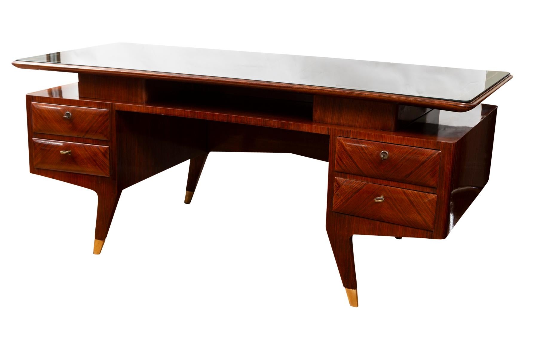 Spectacular Italian Mid Century Curved Executive Desk with a floating plateau displaying its original inset green glass with gold detailing above a base comprised open space and four drawers and finishing on brass sabot feet, brass pulls and keys
