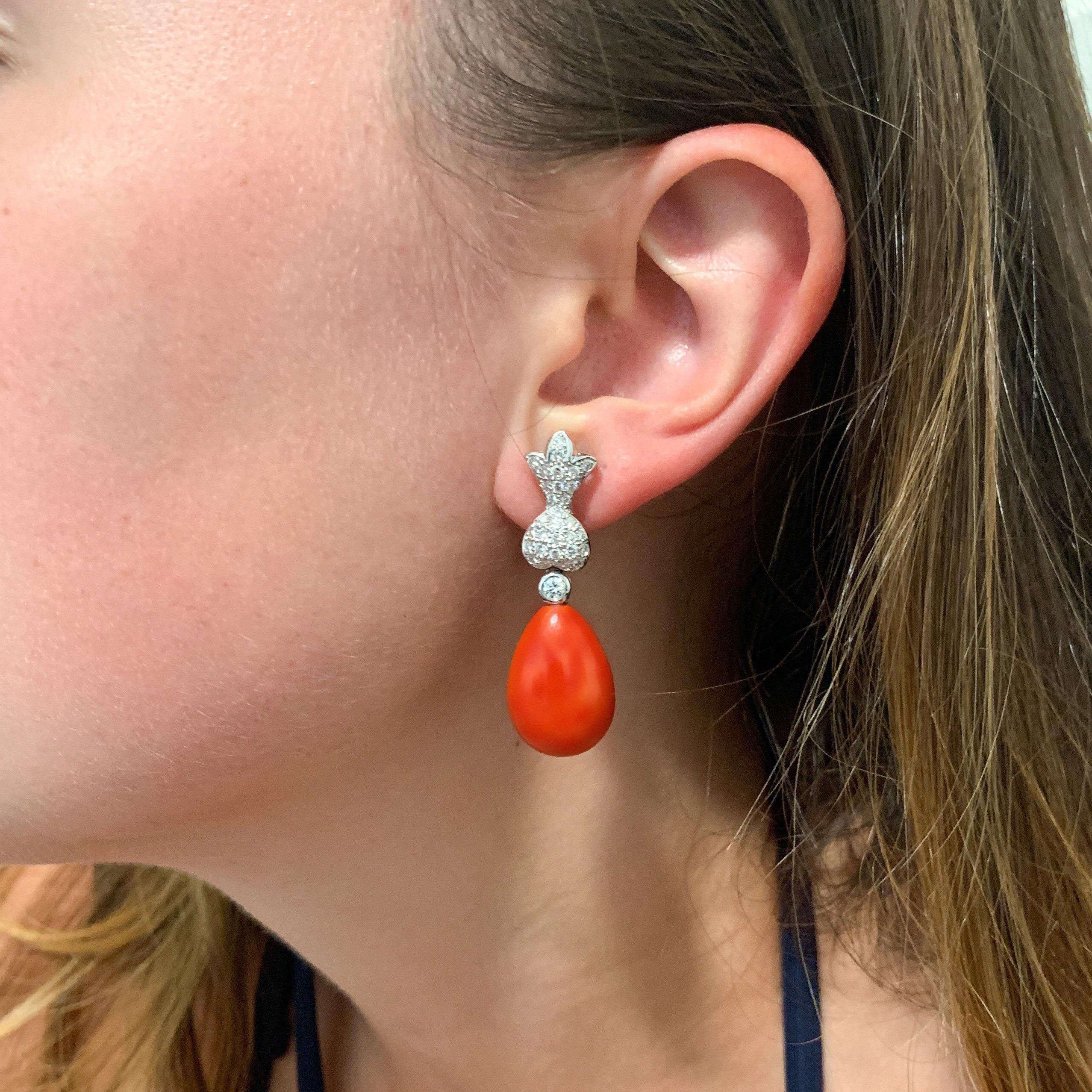 These fine Italian oxblood coral and diamond earrings are elegance at its finest. The beautifully matched coral earrings show off a deep orangy-red hue that is carried evenly throughout both earrings. Minute areas of white on the back and side show