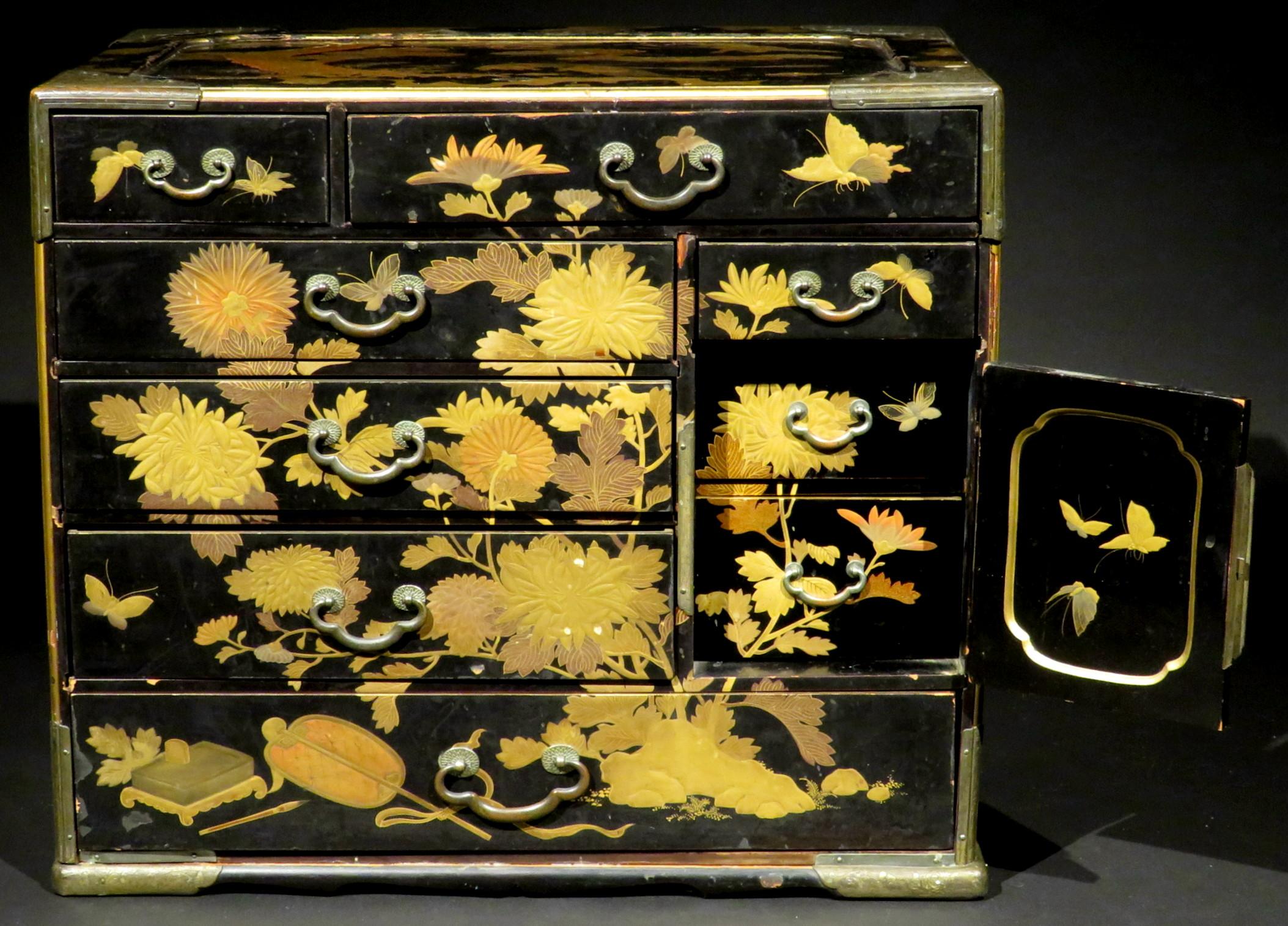 An outstanding 19th century black lacquer tansu decorated overall in hand applied gilt lacquer (maki-e) motifs depicting flower-heads, prunus, scholarly objects and assorted good luck symbols i.e. Rat (prosperity), Turtle (wisdom), Crane (longevity)