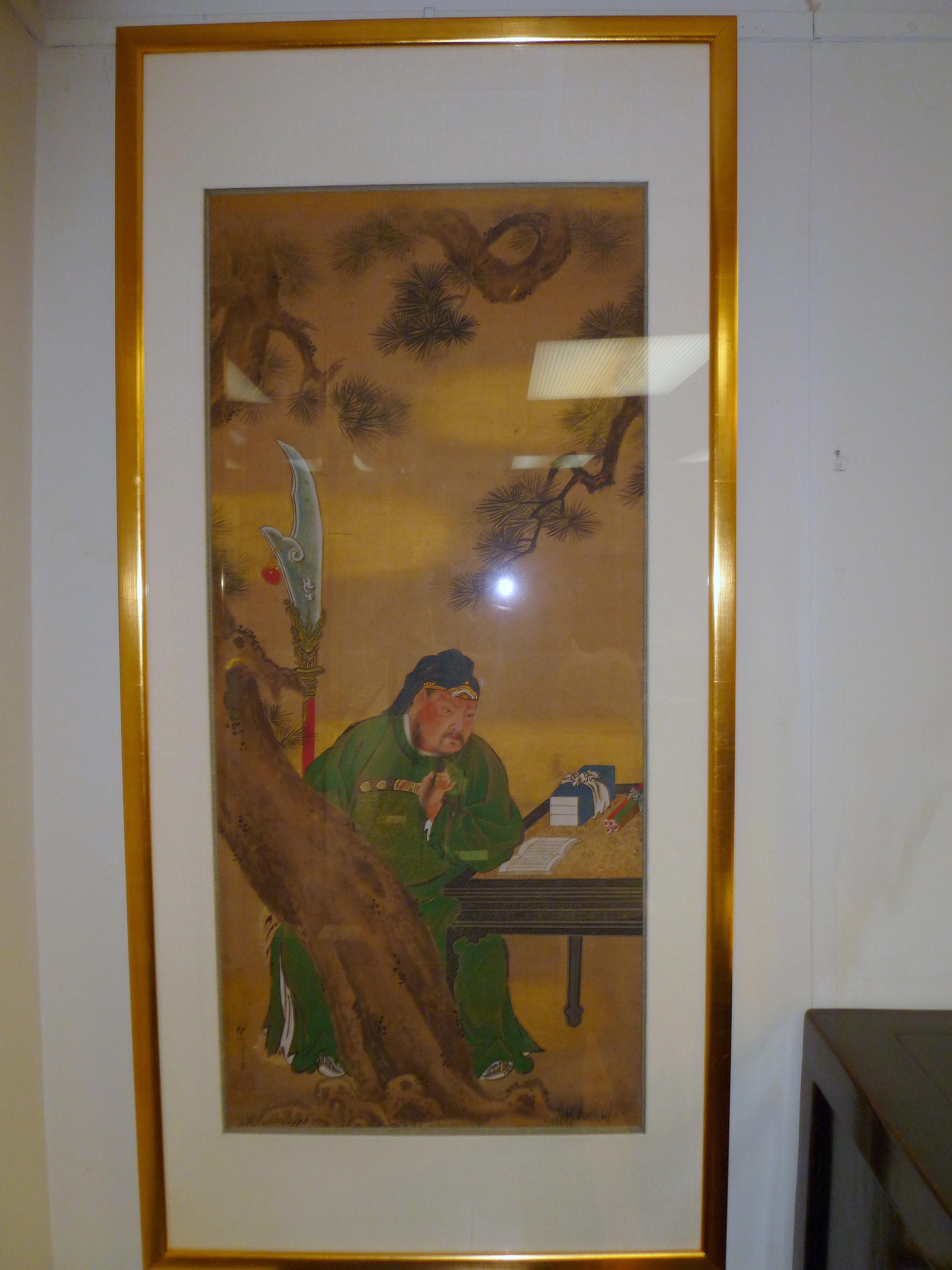 A refined Japanese brush painting of Guan Di reading a book by a pine tree, 19th century, ink and color on silk, Conservation framed