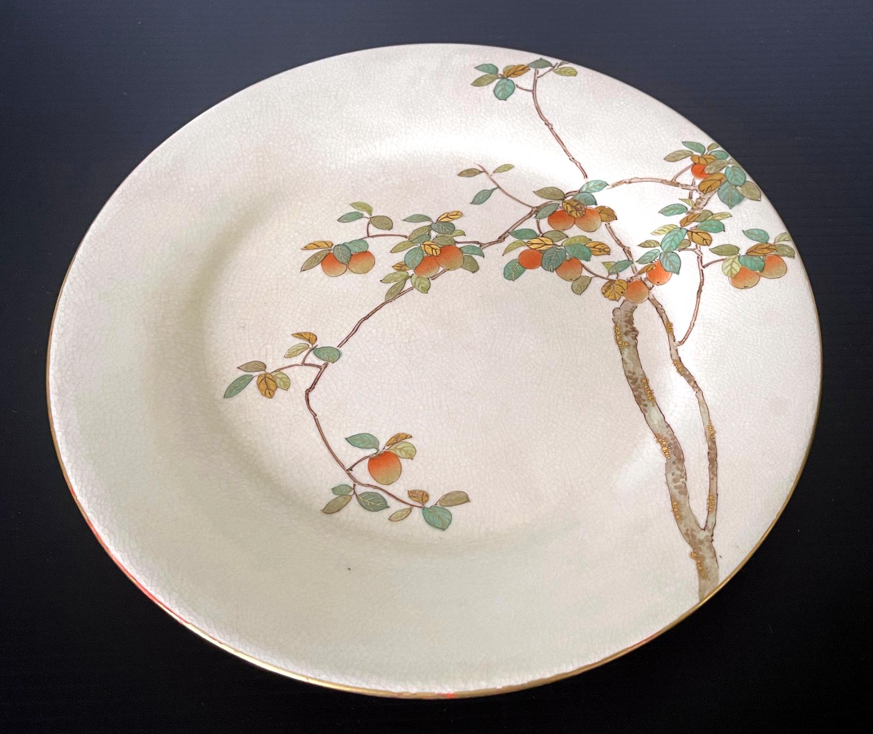 A fine Japanese ceramic satsuma plate made by Kinkozan and retailed by Yamanaka & Co. circa 1900-20s (late Meiji to early Tasho Period). The cream-color glazed plate features a very fine decoration of a persimmon tree bearing fruits. The composition