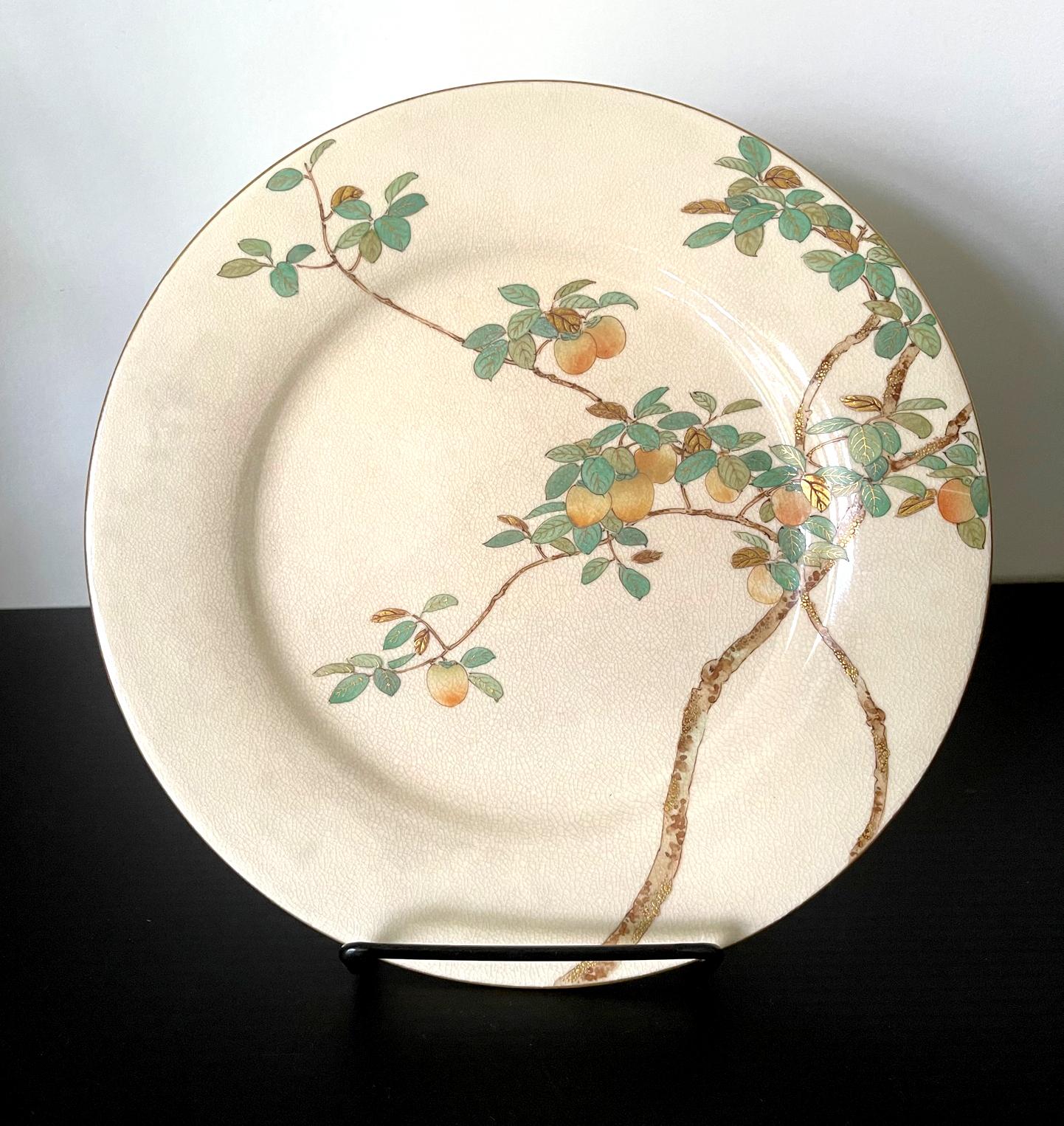 A fine Japanese ceramic satsuma plate made by Kinkozan and retailed by Yamanaka & Co. circa 1900-20s (late Meiji to early Tasho Period). The cream-color glazed plate features a very fine decoration of a persimmon tree bearing fruits. The composition