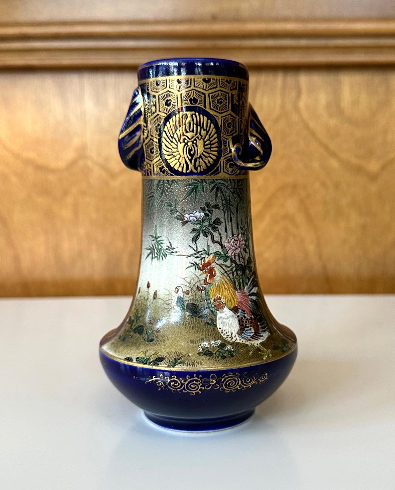 Japanische Miniatur-Keramikvase aus dem Ende der Meiji-Zeit um 1880-1910 von Kinkozan (1645-1927). Einer der größten Studio-Hersteller der damaligen Export-Keramik mit Sitz in Kyoto. Die langhalsige Vase mit Henkeln aus Elefantenohren und elegant