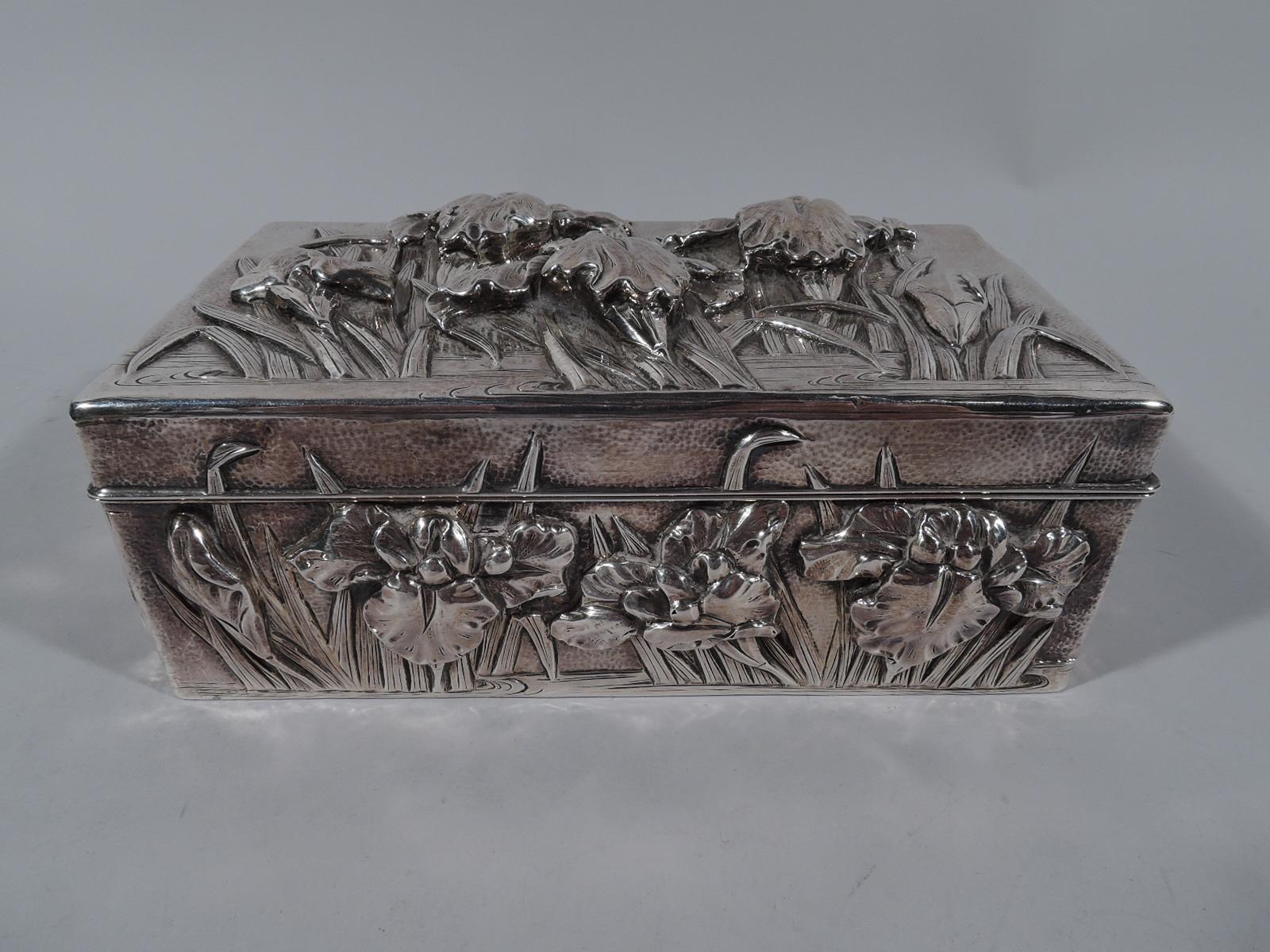 Turn-of-the-century Japanese silver box. Rectangular with hinged cover. Cover top and sides decorated with iris flowers set in eddying water. Ornament applied, chased, and engraved; ground hand hammered. Interior lined with stained wood; bottom