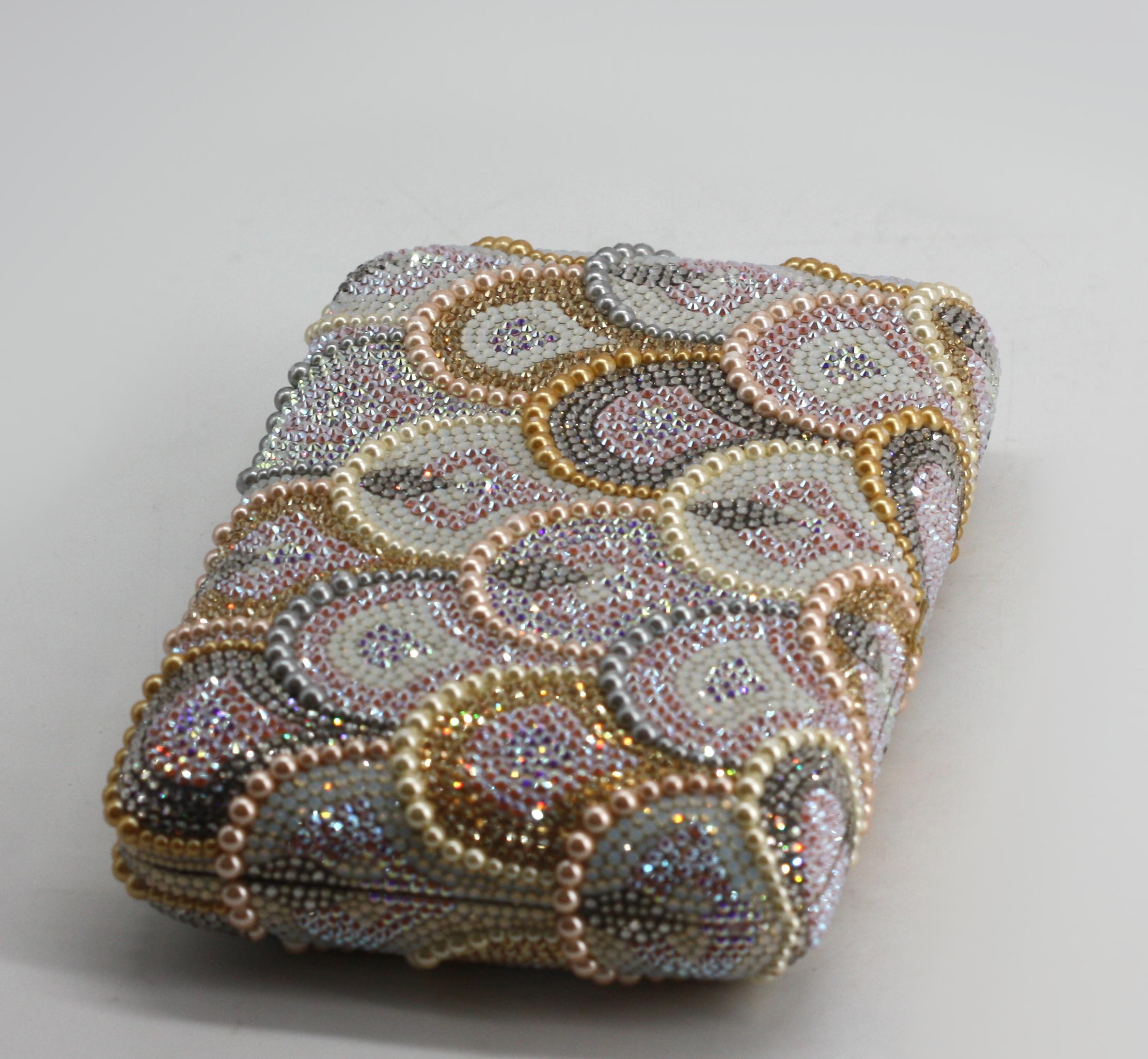 
Judith Leiber Pearl and Crystal Clutch

A dazzling rectangular evening clutch by Judith Leiber, meticulously crafted with overlapping lappets of multi-colored faux pearls and crystals in soft hues of pink, silver, white, and gold. The opulent