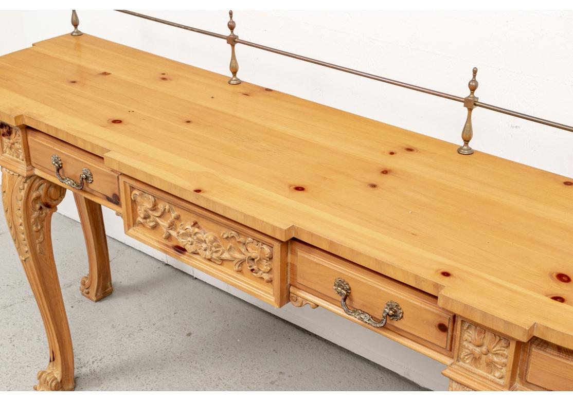 A handsome Carved Pine Console Server in the Georgian Style by Karges Furniture. A shaped carved pine sideboard with curved ends and overhanging top. The back with an open brass back Gallery.  The frieze with a single carved long drawer looking like