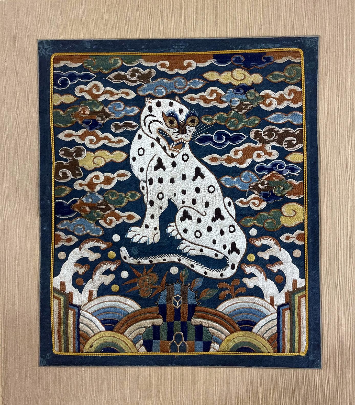 A Korean embroidered silk rank badge (Hyungbae in Korean) from late Joseon Dynasty circa t19th century. One of a fine matching pair, the badge features design of a crouching white tiger- leopards above the Li-sui waves, Lingzi longevity mushroom,