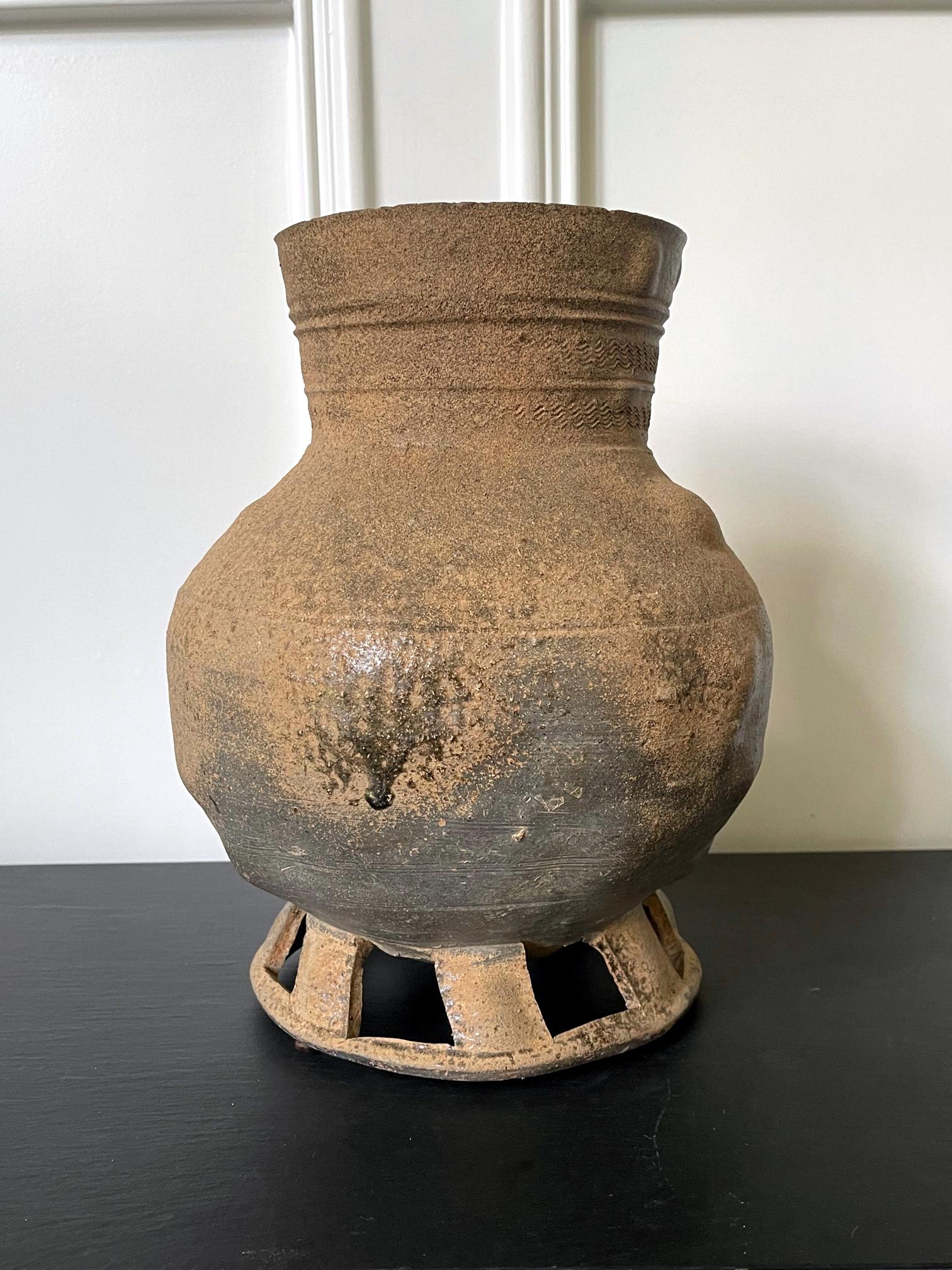 A stoneware jar of bulbous form with a long neck supported by open-work foot dated from Silla, Three Kingdoms period (57 BCE-668 AD). The grey color vessel is of a classic type found as burial objects in the capital city of Gyeongju, in nowadays