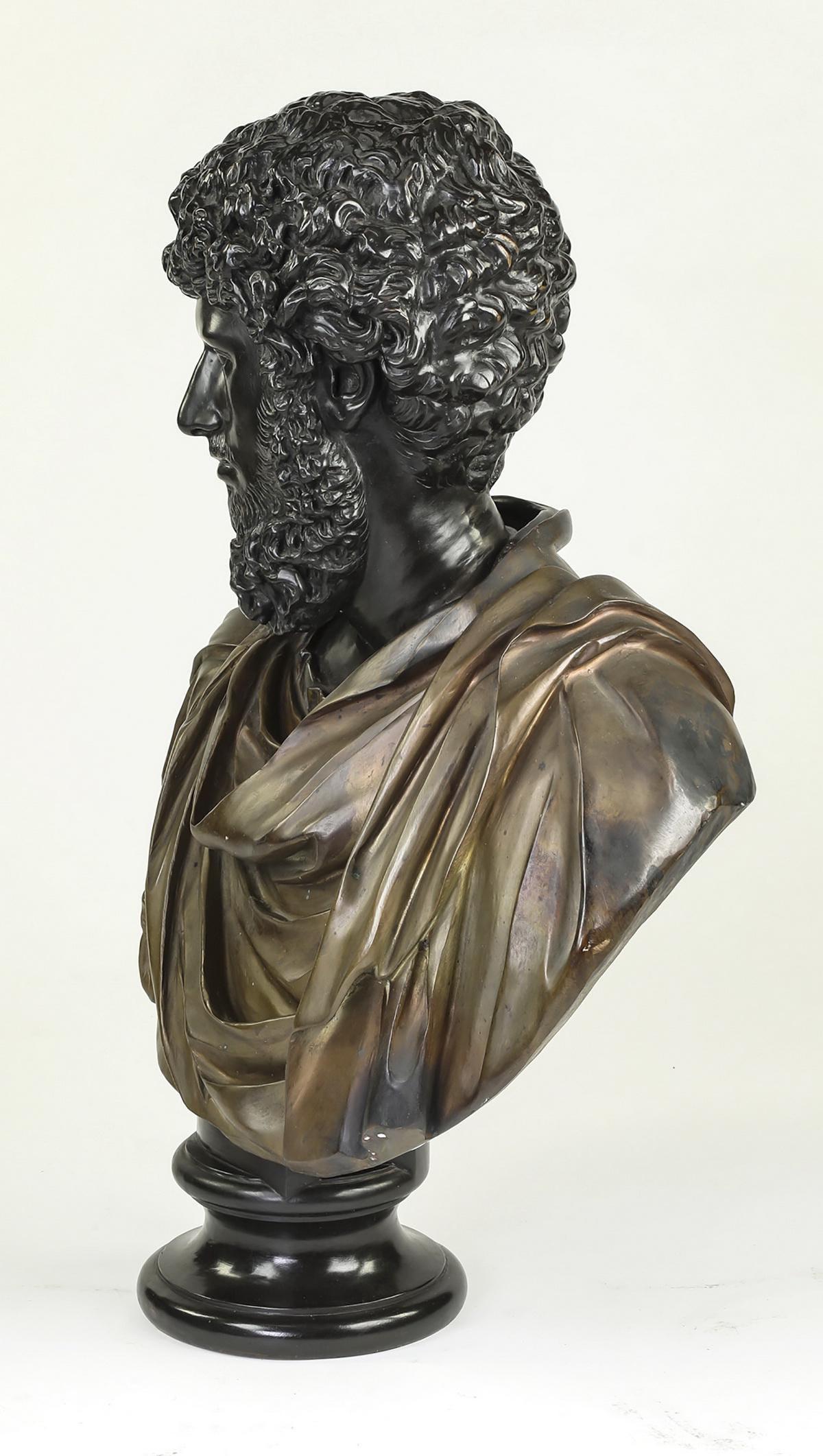 Fine Continental Roman style bronze bust, late 19th century, depicting a curly haired and bearded young man wearing classical drapery pinned on his left shoulder with a circular fibula. Measures: 33