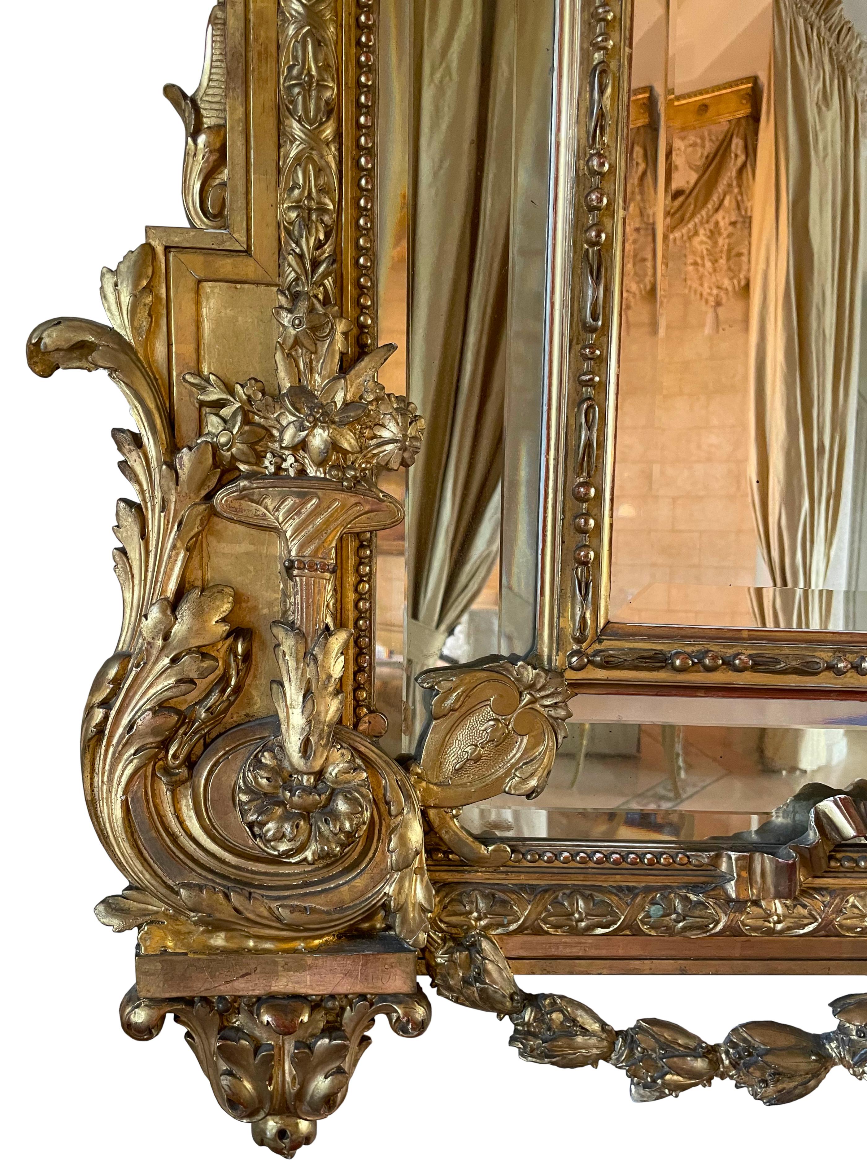 
Grande specchio francese in legno dorato
Circa 1900. In stile neoclassico, la lastra rettangolare sagomata dello specchio, all'interno di un contorno intagliato a foglie e volute, la cresta con una coppia di putti con ghirlande al centro di una