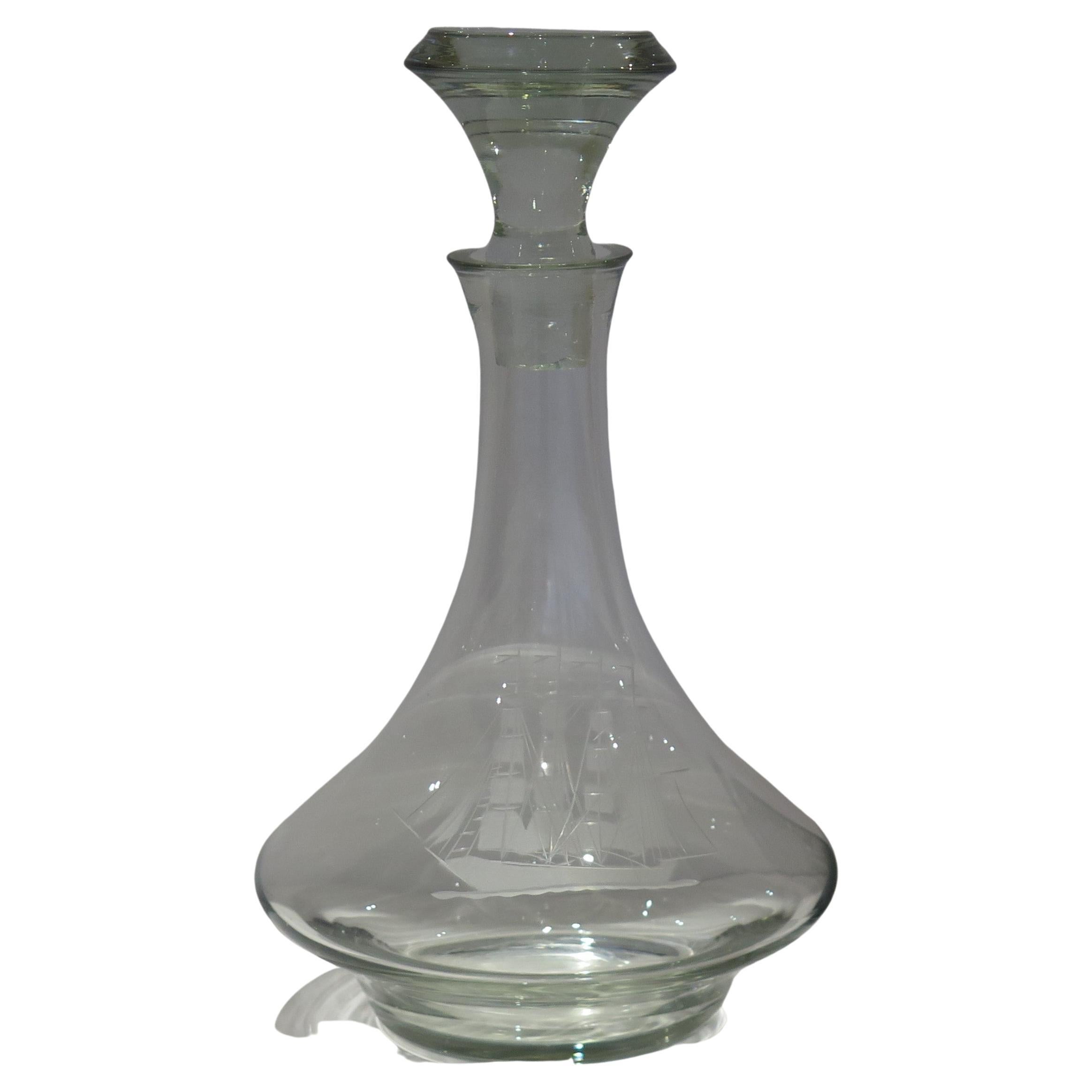 This is a very large ( 1.5 litre) high quality ship's decanter, having an engraved image of a square rigger ship with a wide base made from heavy lead crystal or cut-glass having a soft light grey color.

The decanter sits on a low foot and is made