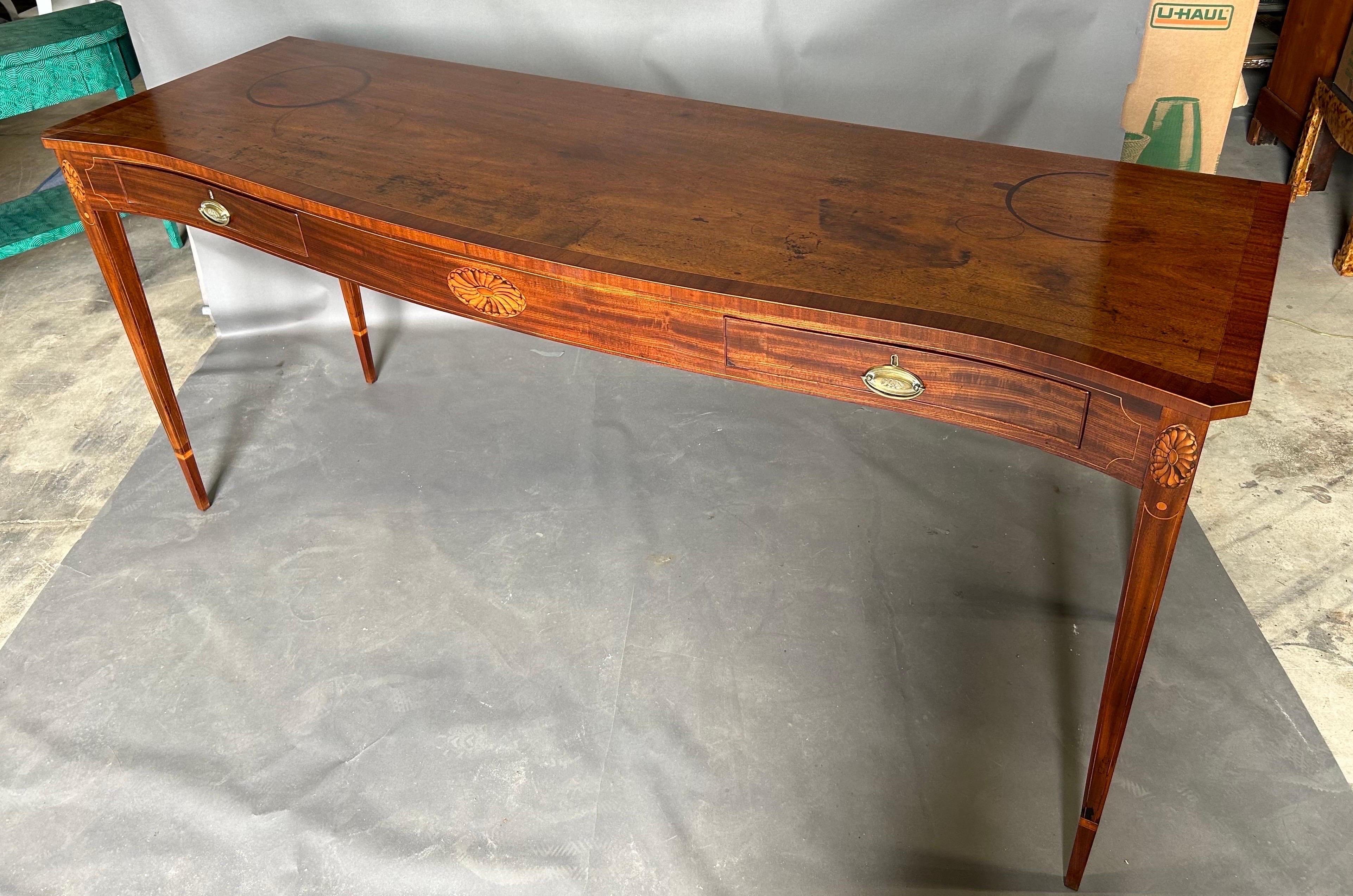 Fine late 18th century Georgian serpentine inlaid mahogany server or sideboard standing 40” high. The sideboard features a highly figured and crossbanded  top, tapered legs, and gorgeous paterae inlay. Wonderful warm mellow finish all over with 