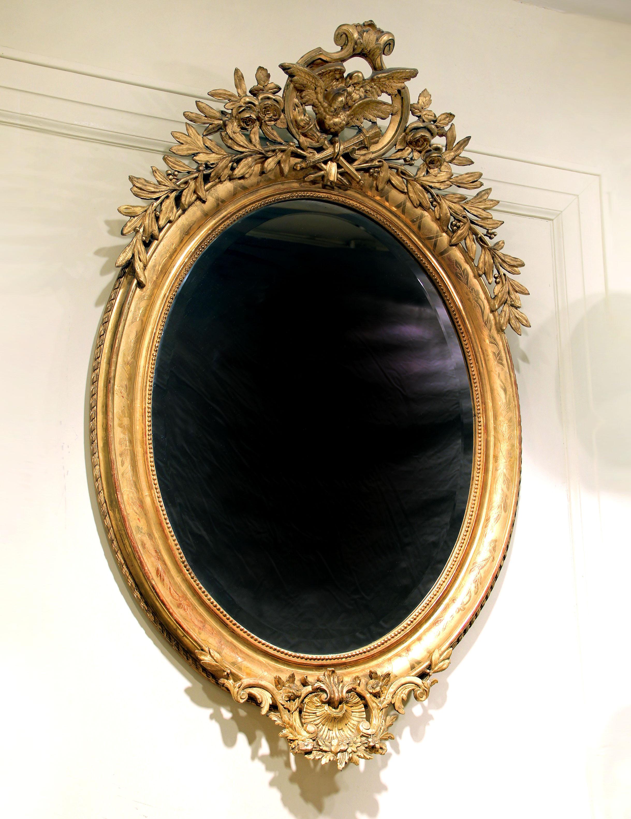 A fine late 19th century carved giltwood and gesso mirror

Of oval form with dove 