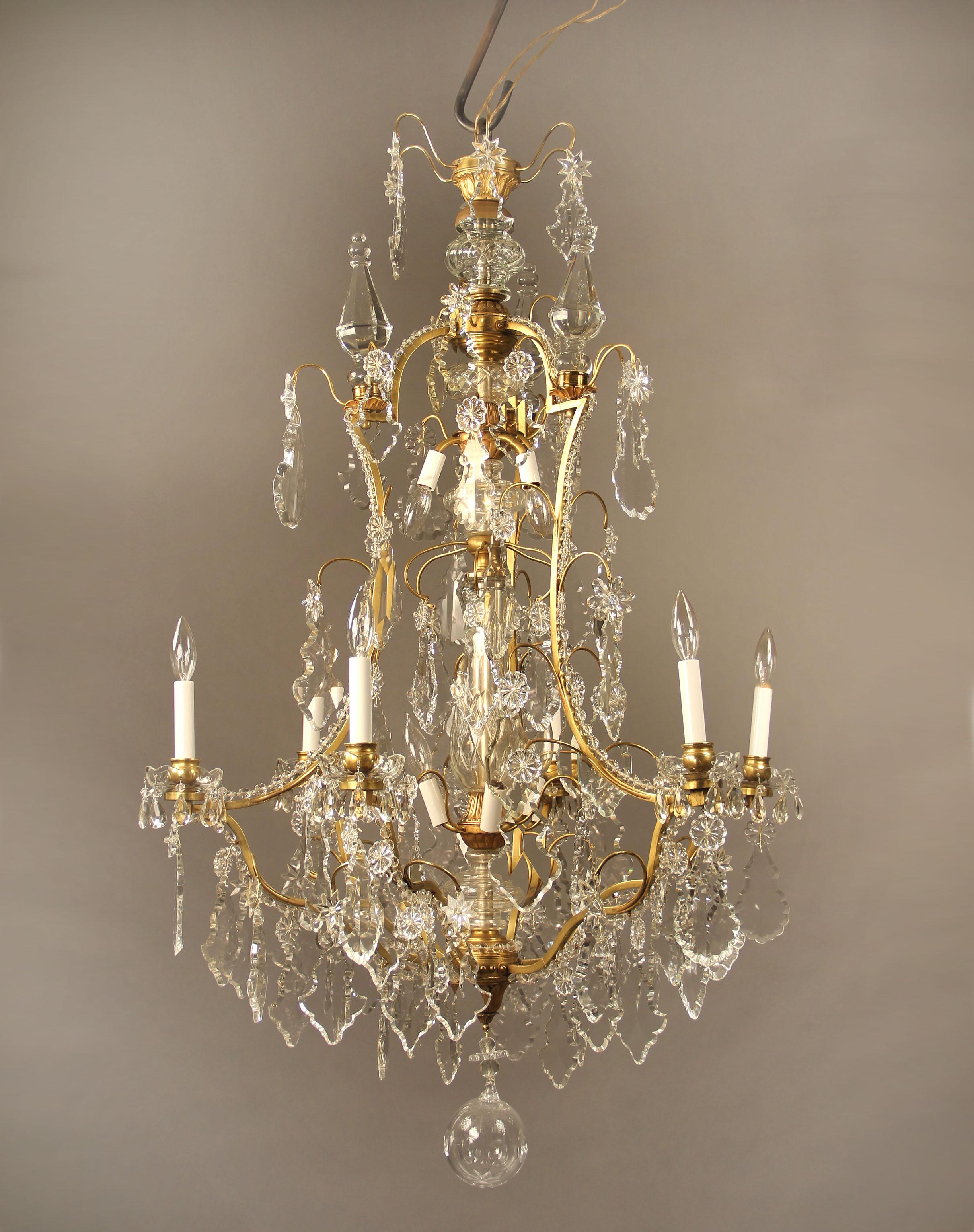 A fine late 19th century gilt bronze and crystal twelve-light chandelier

Multifaceted and shaped crystal, beaded arms and three spears. Cut crystal central column, six perimeter and six tiered interior lights.