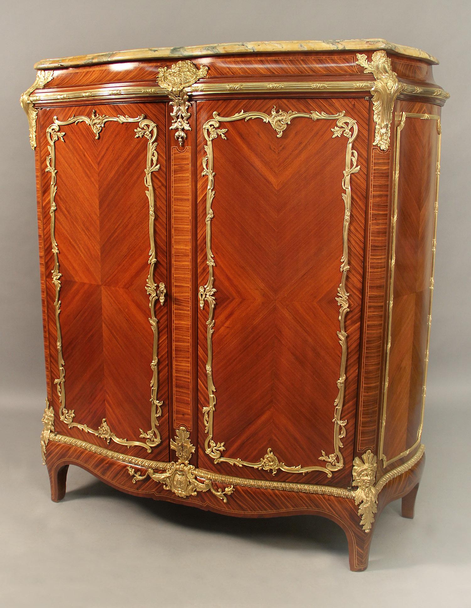 A fine Late 19th century Gilt Bronze Mounted Transitional Style Tall Cabinet By François Linke

François Linke

The marble top above two long doors, the front and sides quarter veneered. The top centered with a gilt bronze mask of Bacchus, the